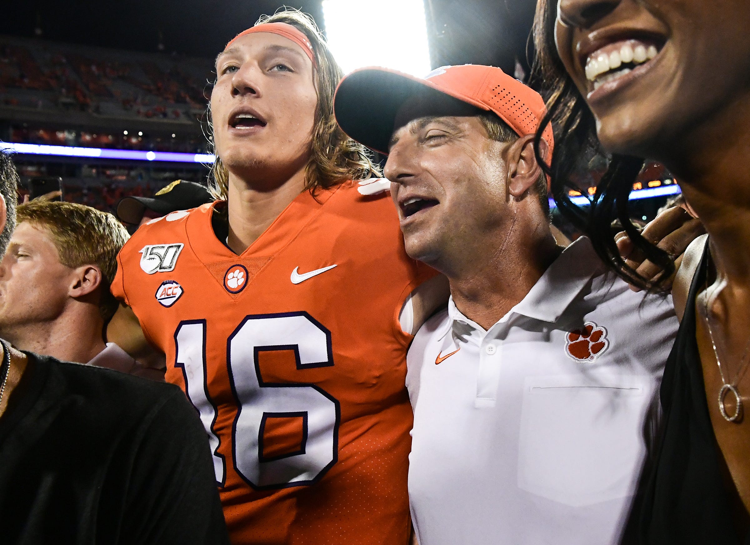 Clemson quarterback Trevor Lawrence (16) and head coach Dabo Swinney join in singing the alma mater with fans after the game at Memorial Stadium in Clemson Thursday, August 29, 2019.