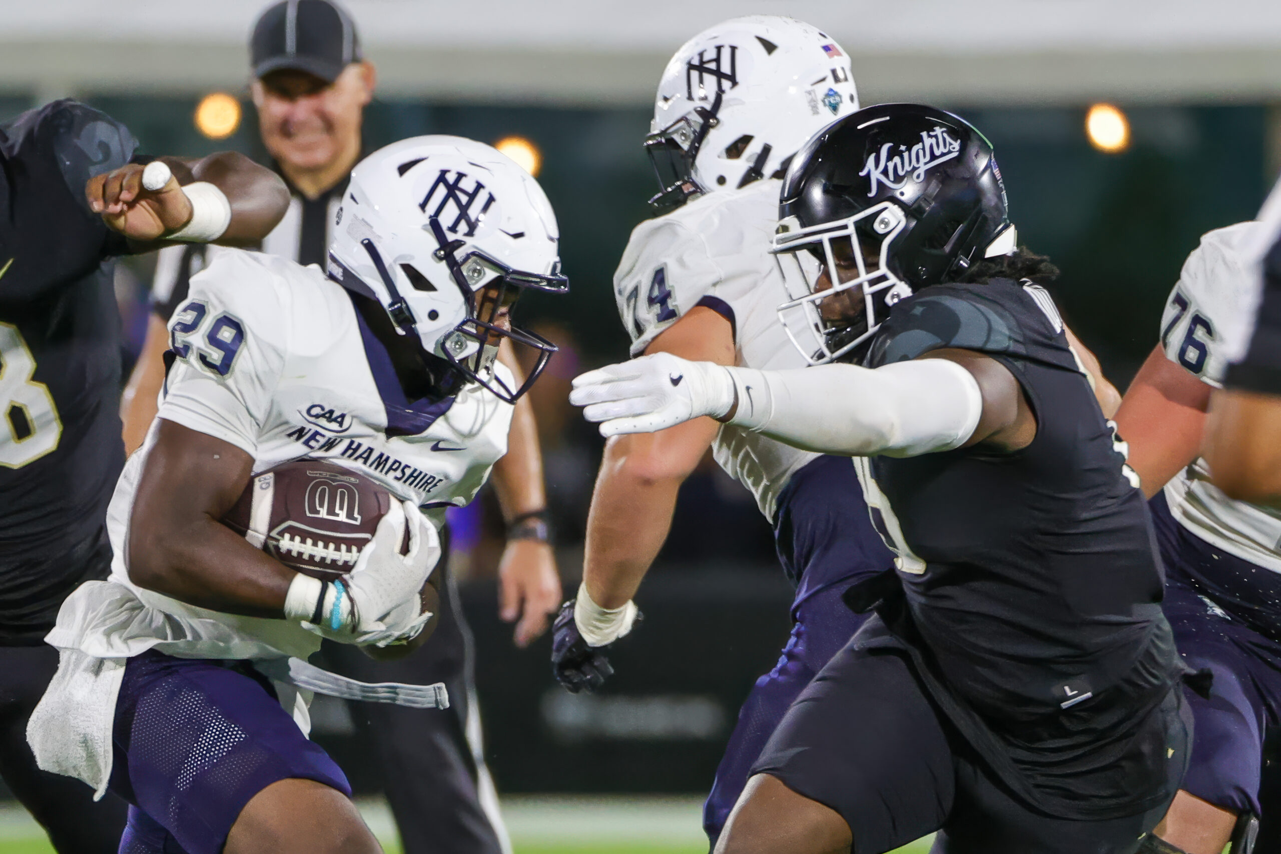 Aug 29, 2024; Orlando, Florida, USA; New Hampshire Wildcats running back Denzell Gibson (29) carries the ball as UCF Knights defensive end Daylan Dotson (15) moves in during the second half at FBC Mortgage Stadium.