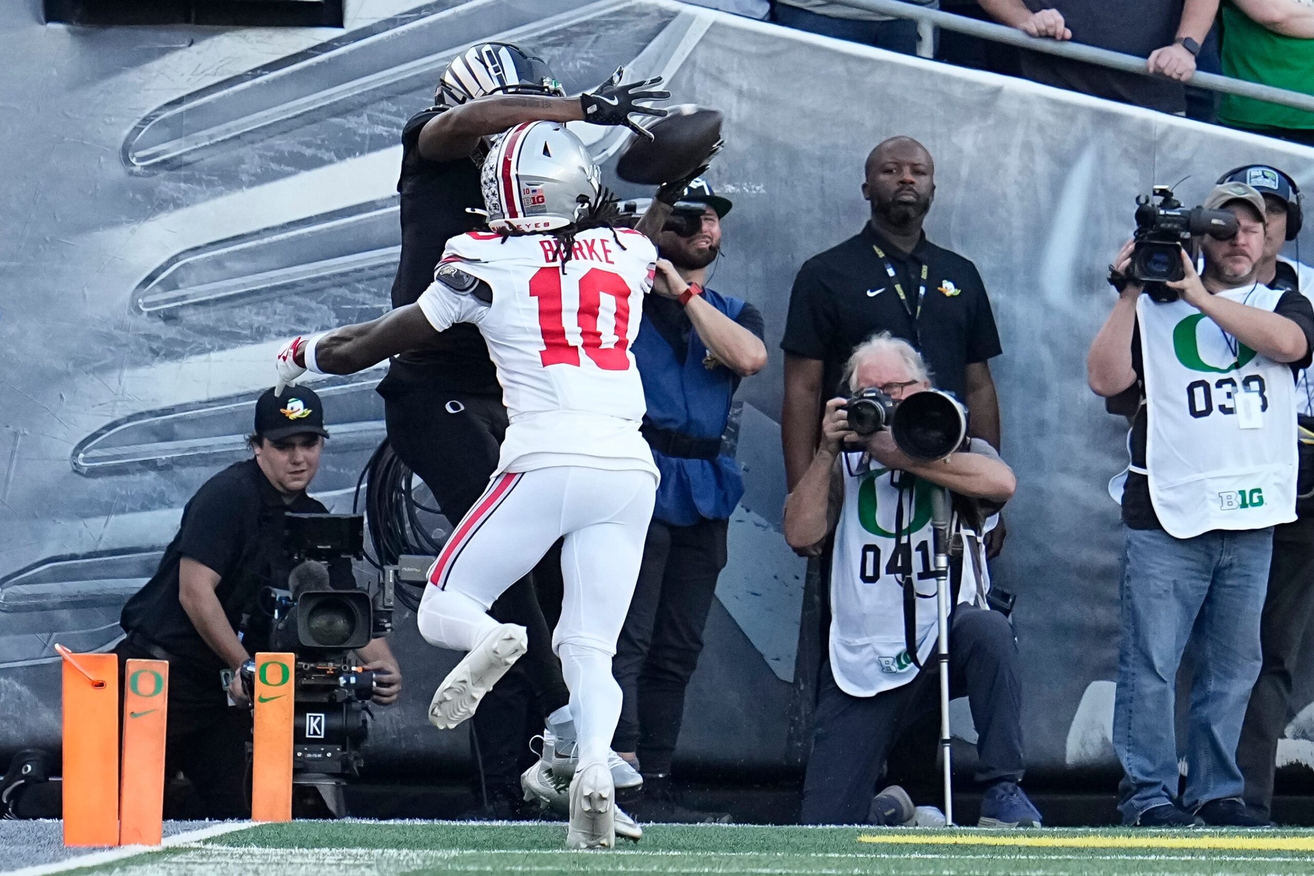 Oct 12, 2024; Eugene, Oregon, USA; Oregon Ducks wide receiver Evan Stewart (7) catches a touchdown over Ohio State Buckeyes cornerback Denzel Burke (10) during the first half of the NCAA football game at Autzen Stadium
