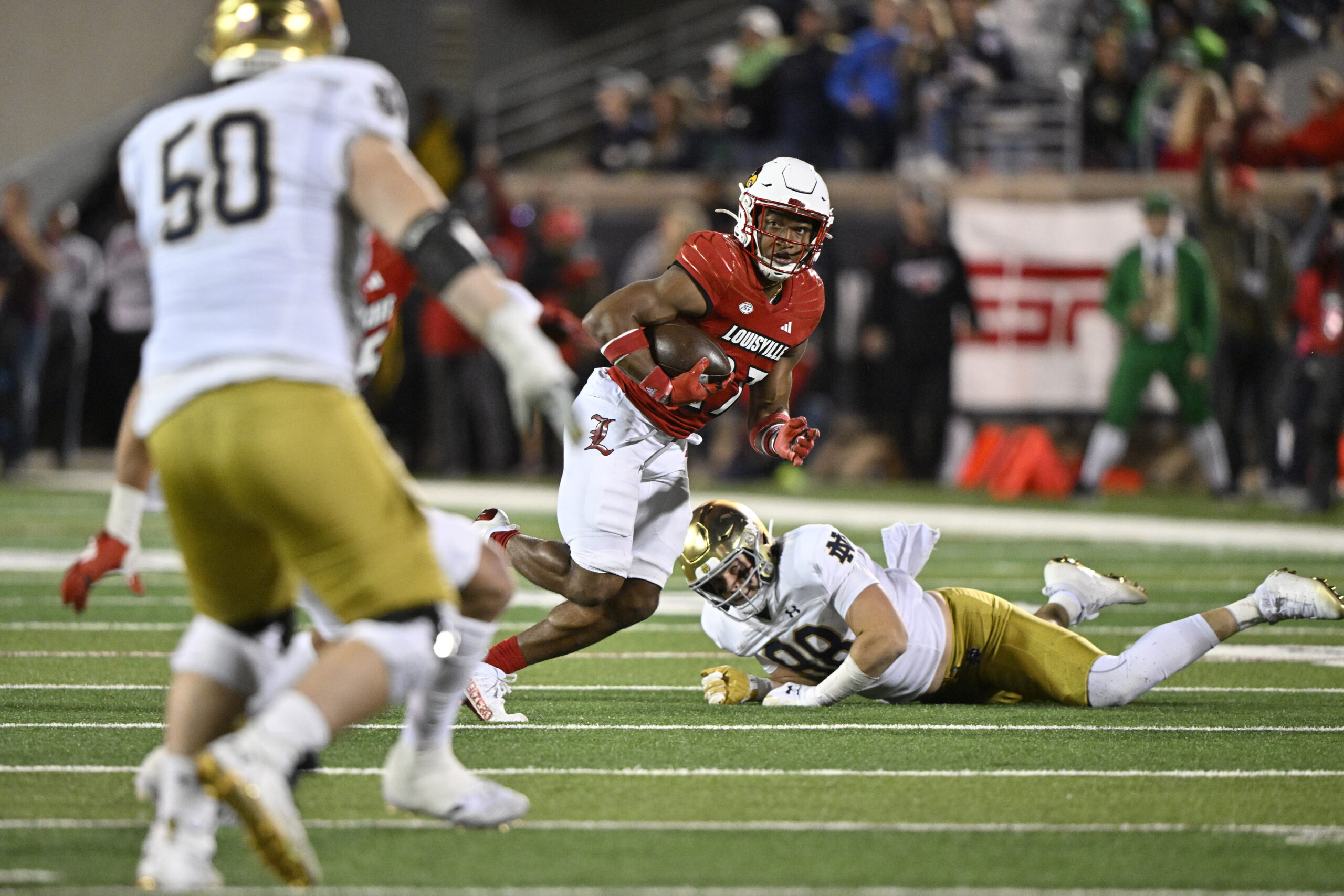 Oct 7, 2023; Louisville, Kentucky, USA; Louisville Cardinals defensive back Devin Neal (27) returns an interception past Notre Dame Fighting Irish tight end Mitchell Evans (88) during the second half at L&N Federal Credit Union Stadium. Louisville defeated Notre Dame 33-20. 