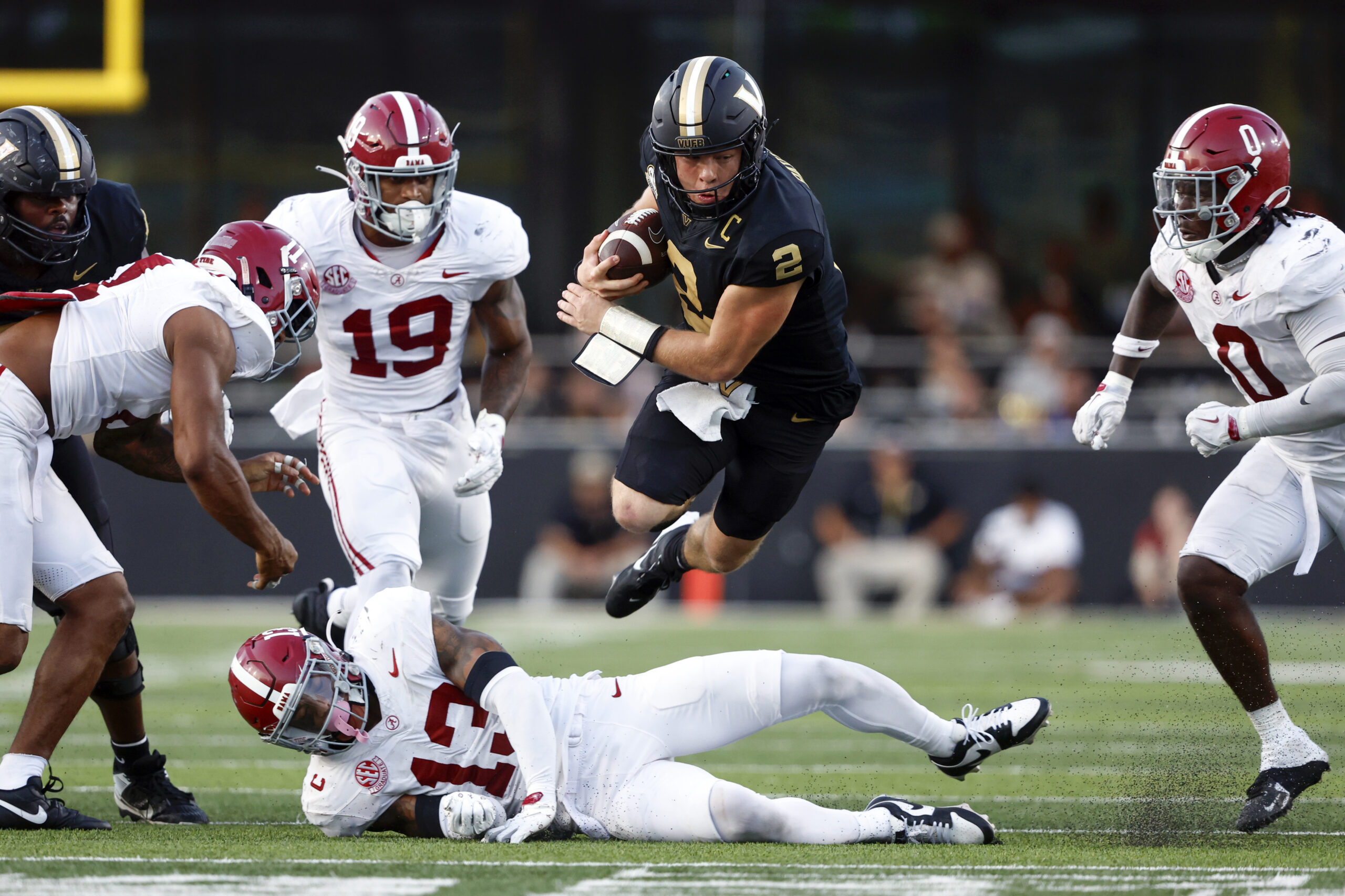 Oct 5, 2024; Nashville, Tennessee, USA; Vanderbilt Commodores quarterback Diego Pavia (2) jumps over Alabama Crimson Tide defensive back Malachi Moore (13) for a first down during the second half at FirstBank Stadium. 