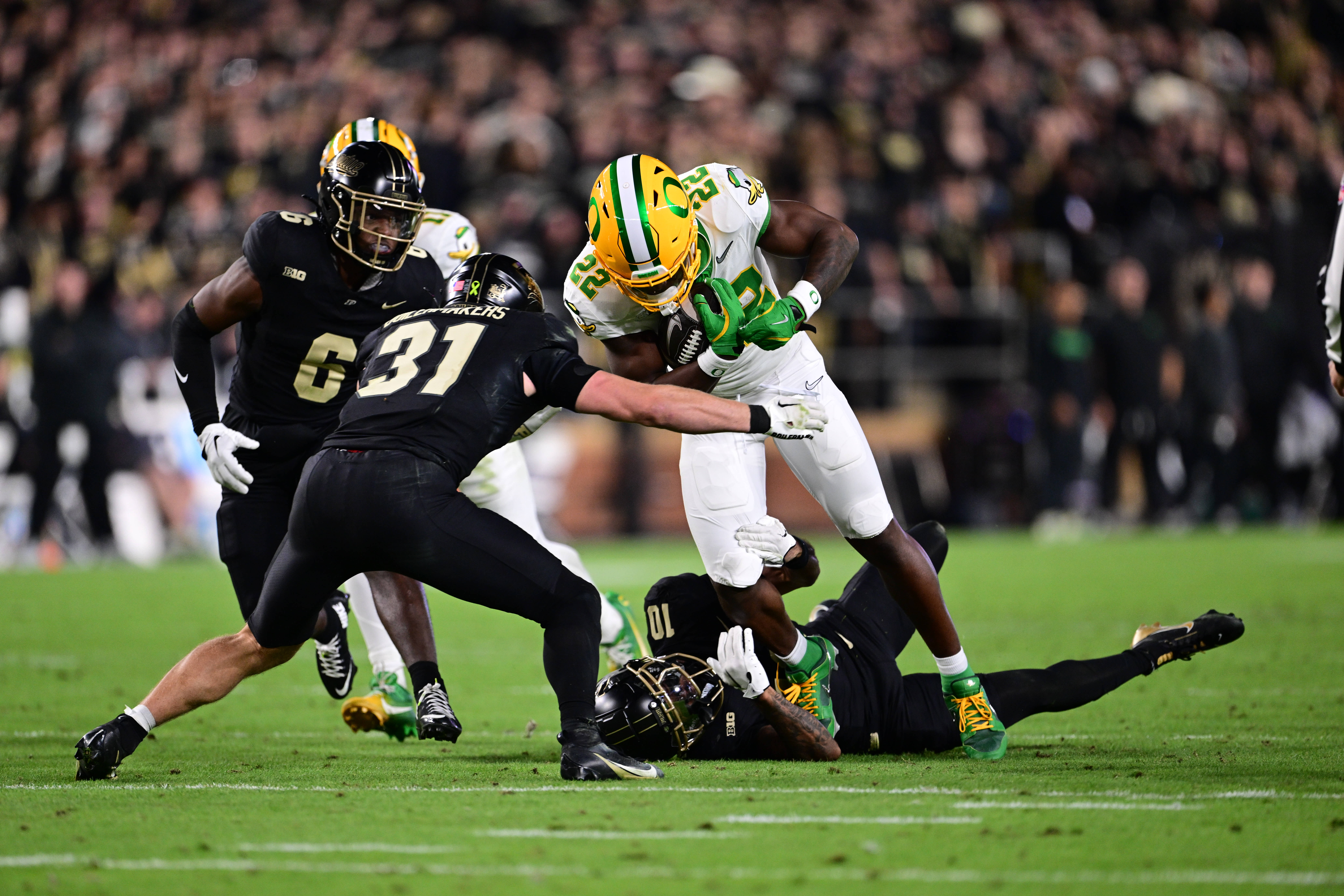 Oct 18, 2024; West Lafayette, Indiana, USA; Oregon Ducks running back Jay Harris (22) is tackled by Purdue Boilermakers defensive back Dillon Thieneman (31) during the second half at Ross-Ade Stadium.
