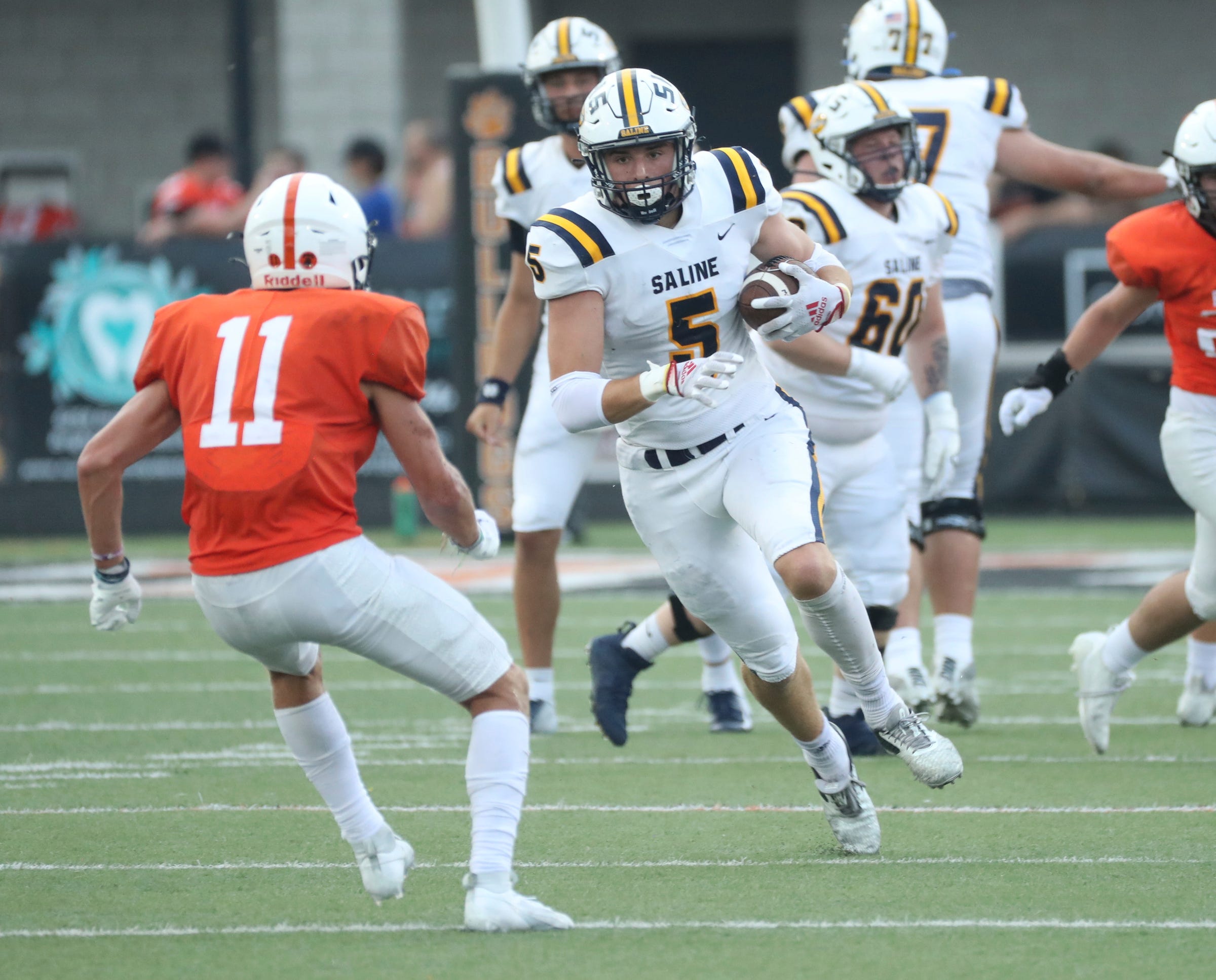 Saline receiver Dylan Mesman makes a catch against Brighton defender Mitchell Rucinski during first-half action at Brighton High School on Thursday, Aug. 24, 2023.