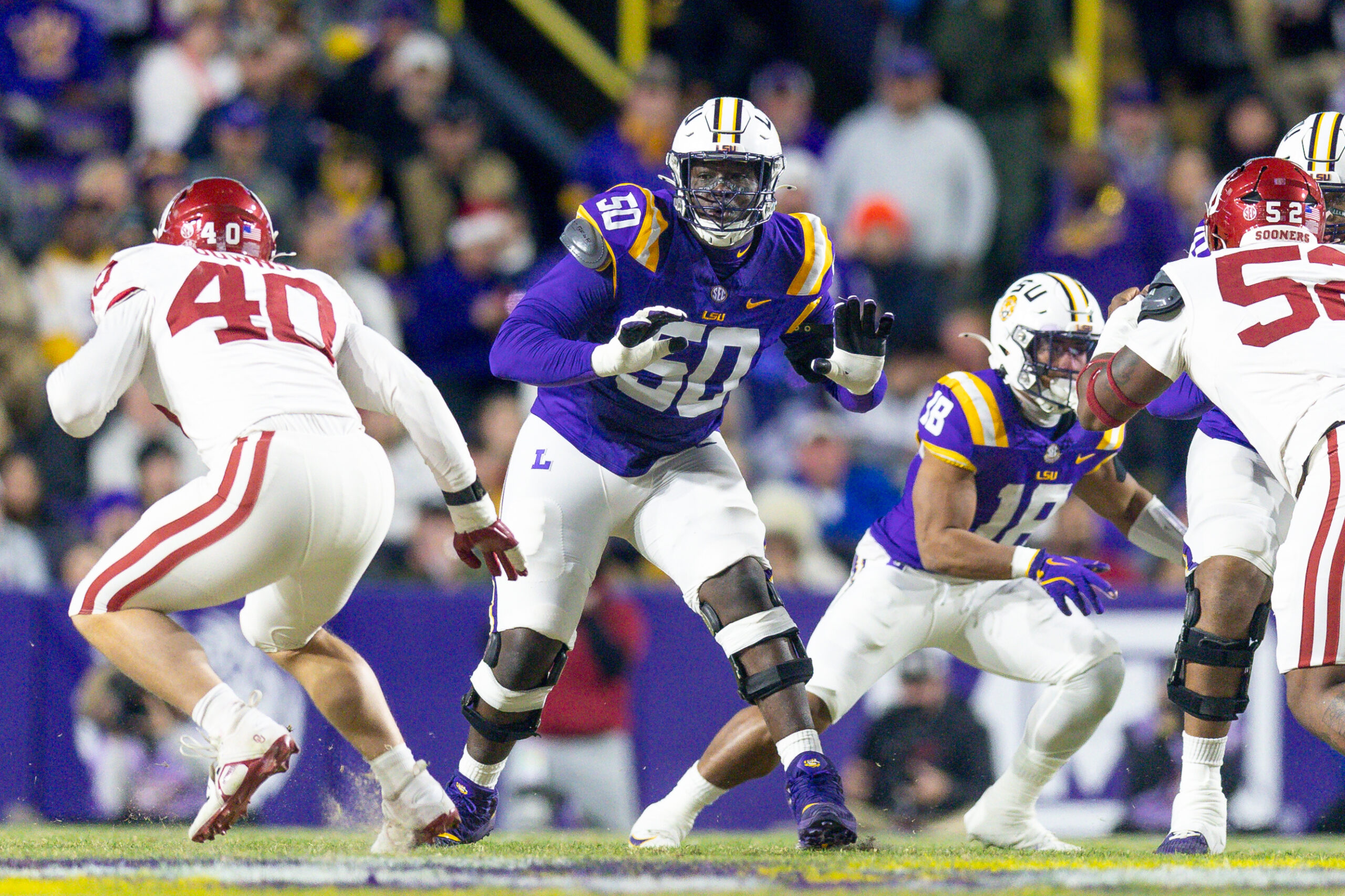 Nov 30, 2024; Baton Rouge, Louisiana, USA; LSU Tigers offensive lineman Emery Jones Jr. (50) defends the line against Oklahoma Sooners defensive lineman Ethan Downs (40) during the first quarter at Tiger Stadium.