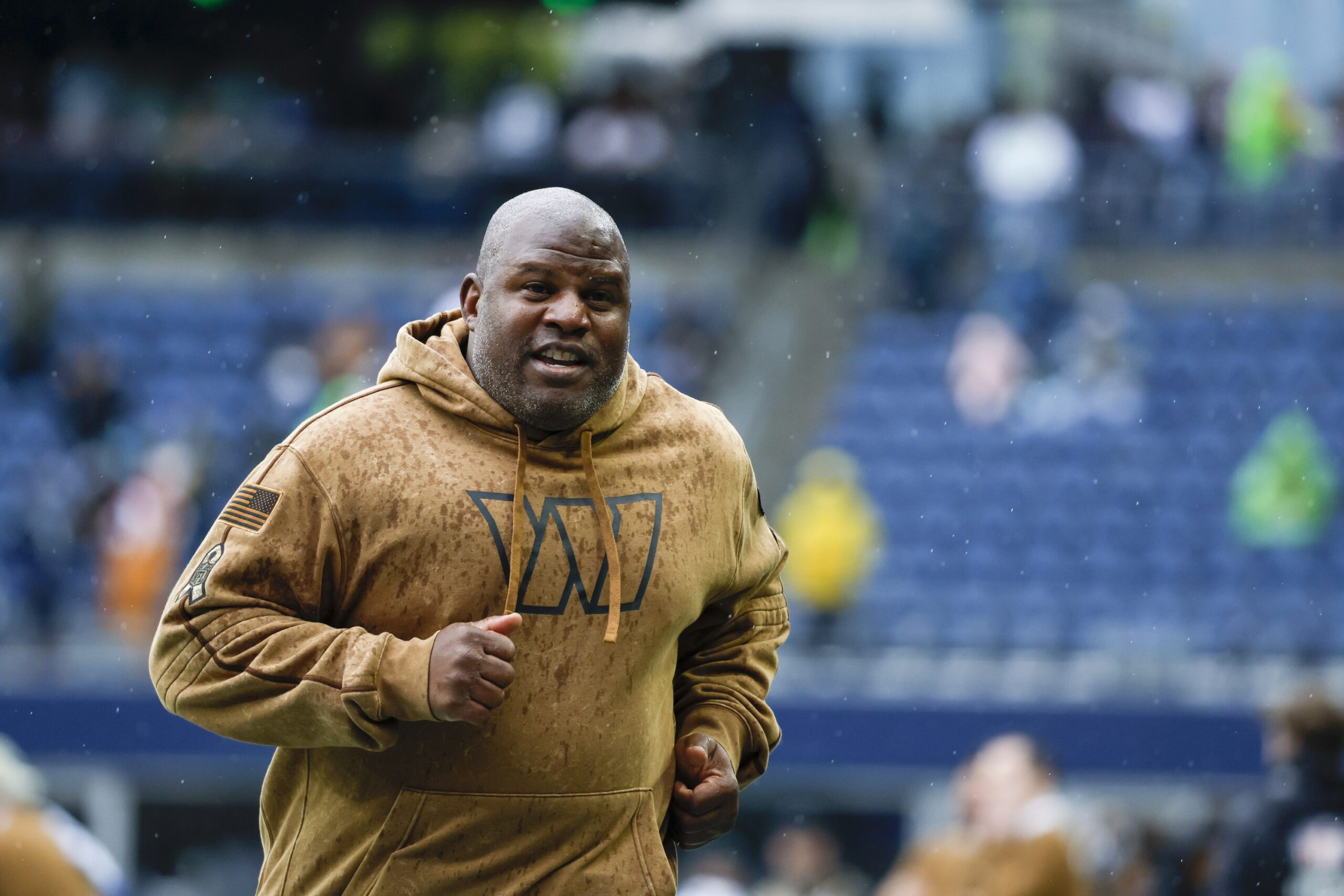 Nov 12, 2023; Seattle, Washington, USA; Washington Commanders offensive coordinator Eric Bieniemy jogs to the locker room following pregame warmups against the Seattle Seahawks at Lumen Field.