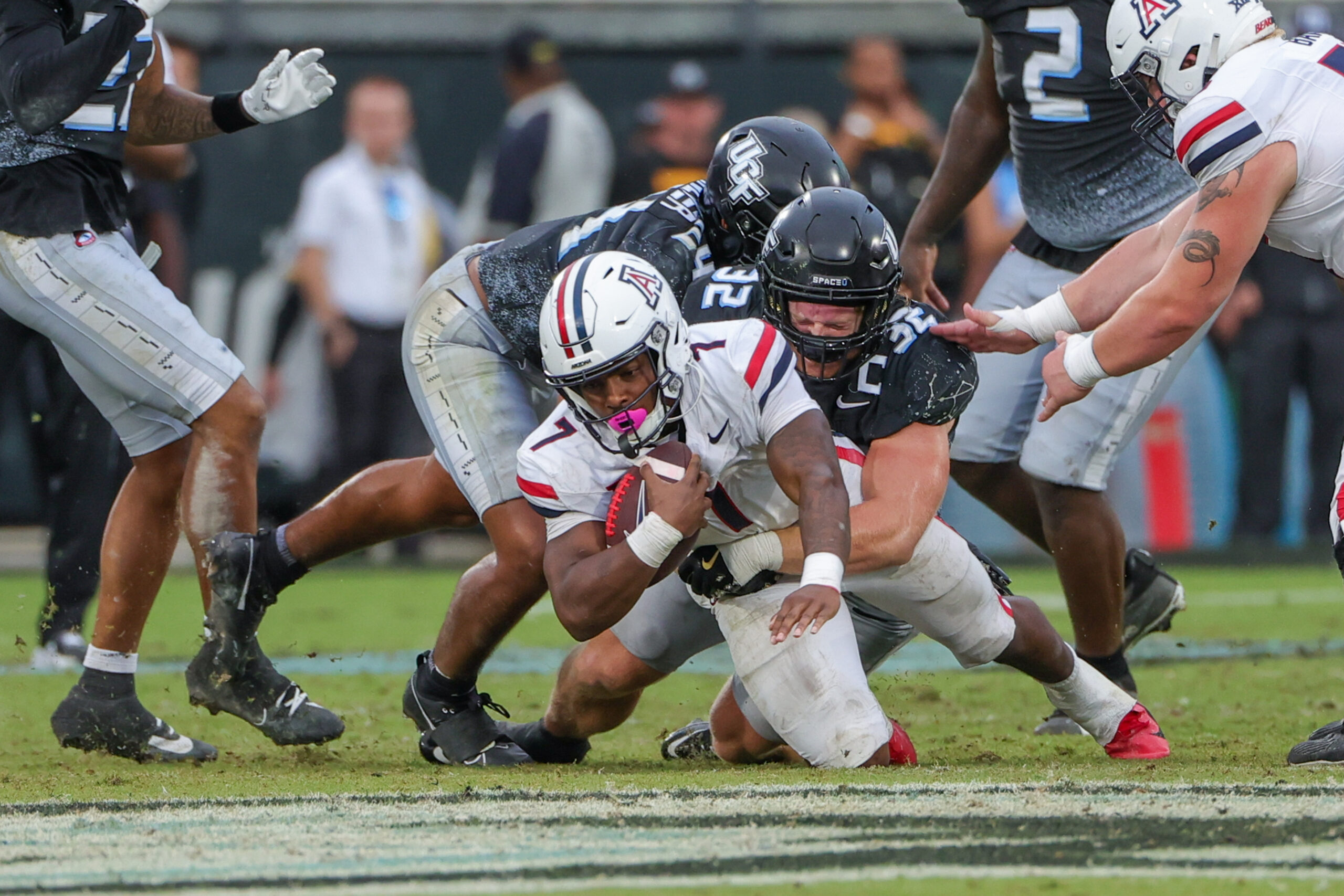 Nov 2, 2024; Orlando, Florida, USA; Arizona Wildcats running back Quali Conley (7) is tackled by UCF Knights linebacker Ethan Barr (32) during the second half at FBC Mortgage Stadium.