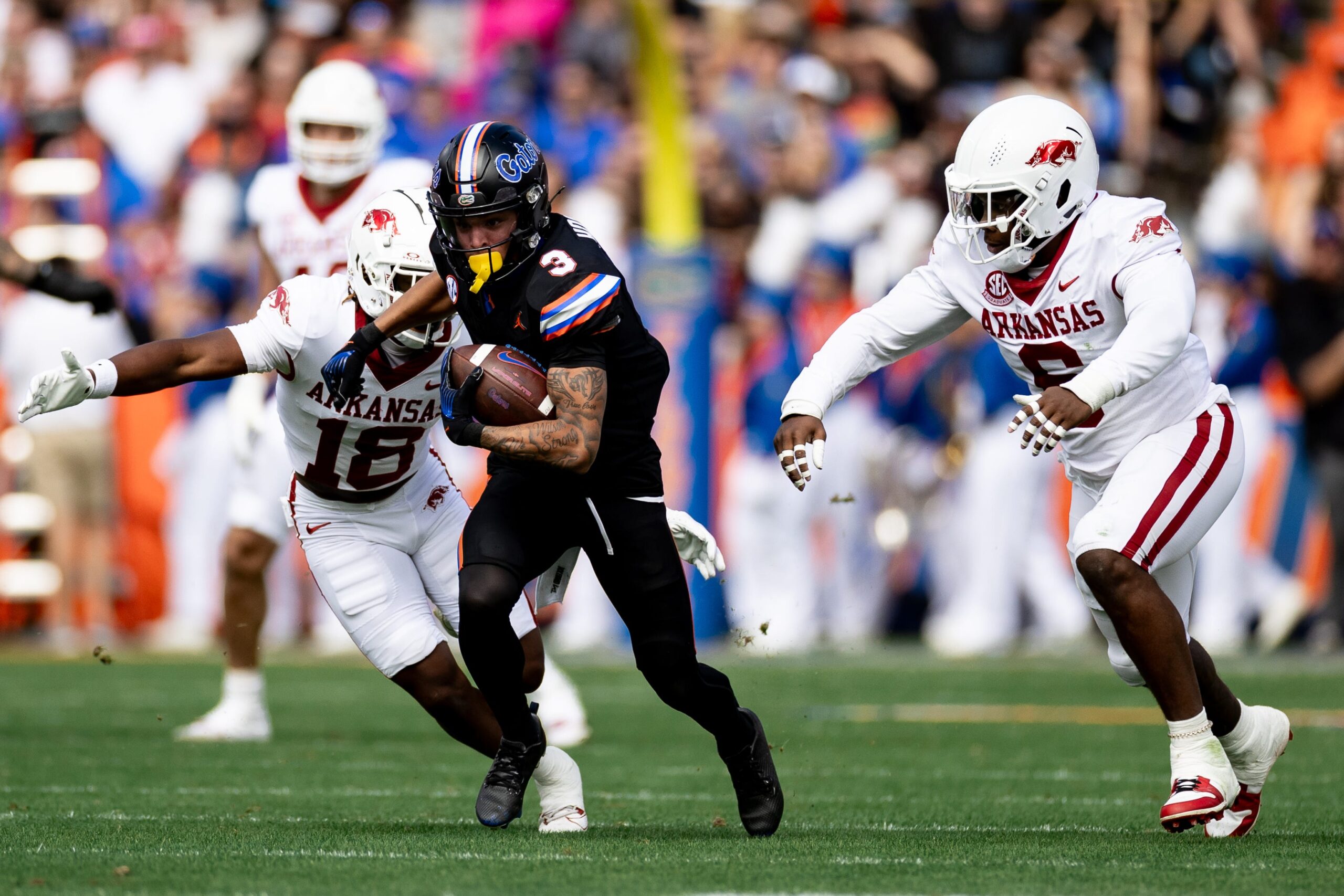 Florida Gators wide receiver Eugene Wilson III (3) breaks free from Arkansas Razorbacks defensive back TJ Metcalf (18) and Arkansas Razorbacks defensive lineman John Morgan III (6) during the first half at Steve Spurrier Field at Ben Hill Griffin Stadium in Gainesville, FL on Saturday, November 4, 2023.