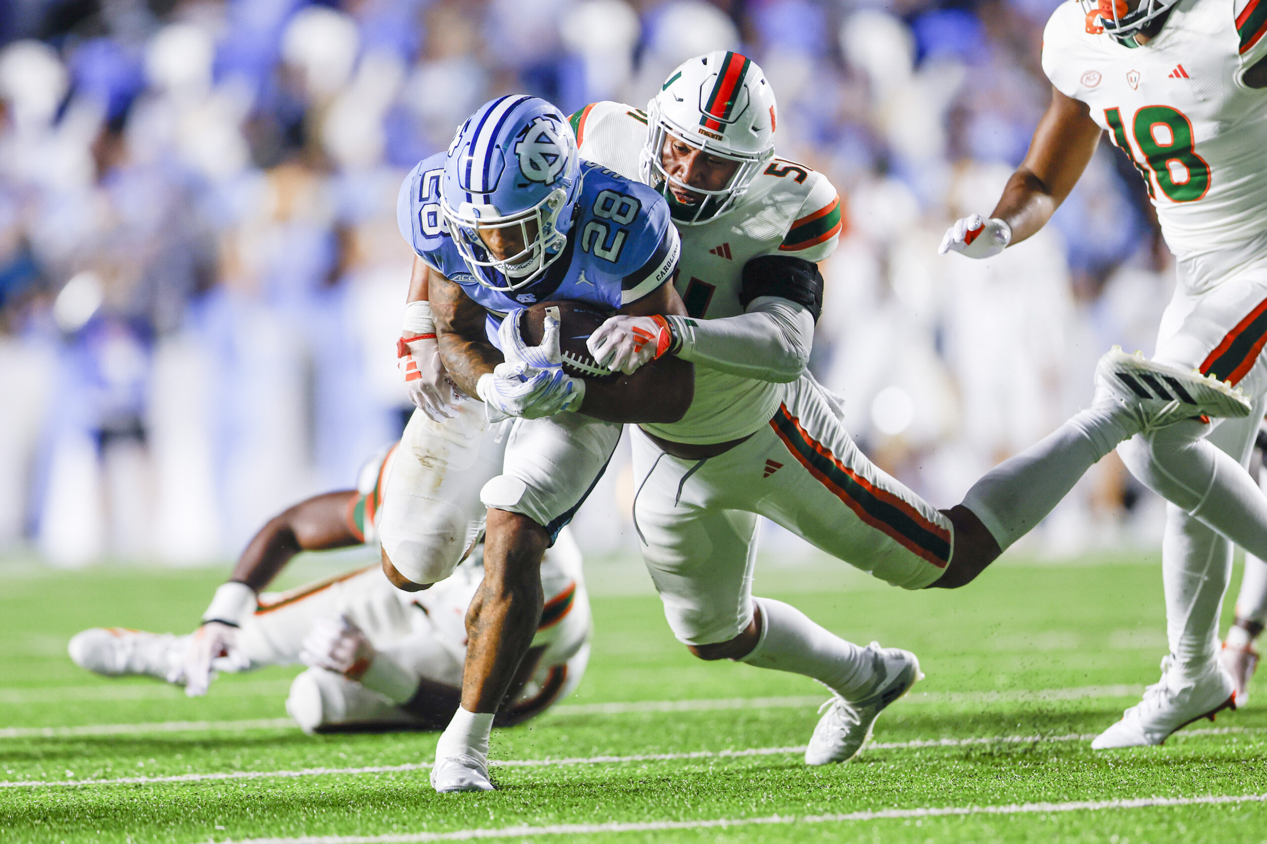 Oct 14, 2023; Chapel Hill, North Carolina, USA; North Carolina Tar Heels running back Omarion Hampton (28) fights for yards against Miami Hurricanes linebacker Francisco Mauigoa (51) during the second half at Kenan Memorial Stadium.