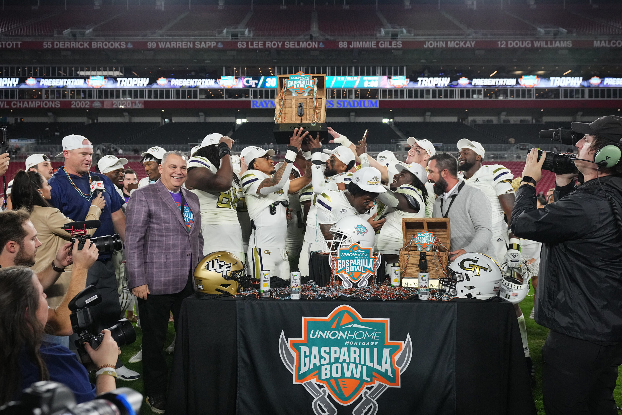 Dec 22, 2023; Tampa, FL, USA; Georgia Tech Yellow Jackets teammates celebrate with the trophy after defeating the UCF Knights in the Gasparilla Bowl at Raymond James Stadium.