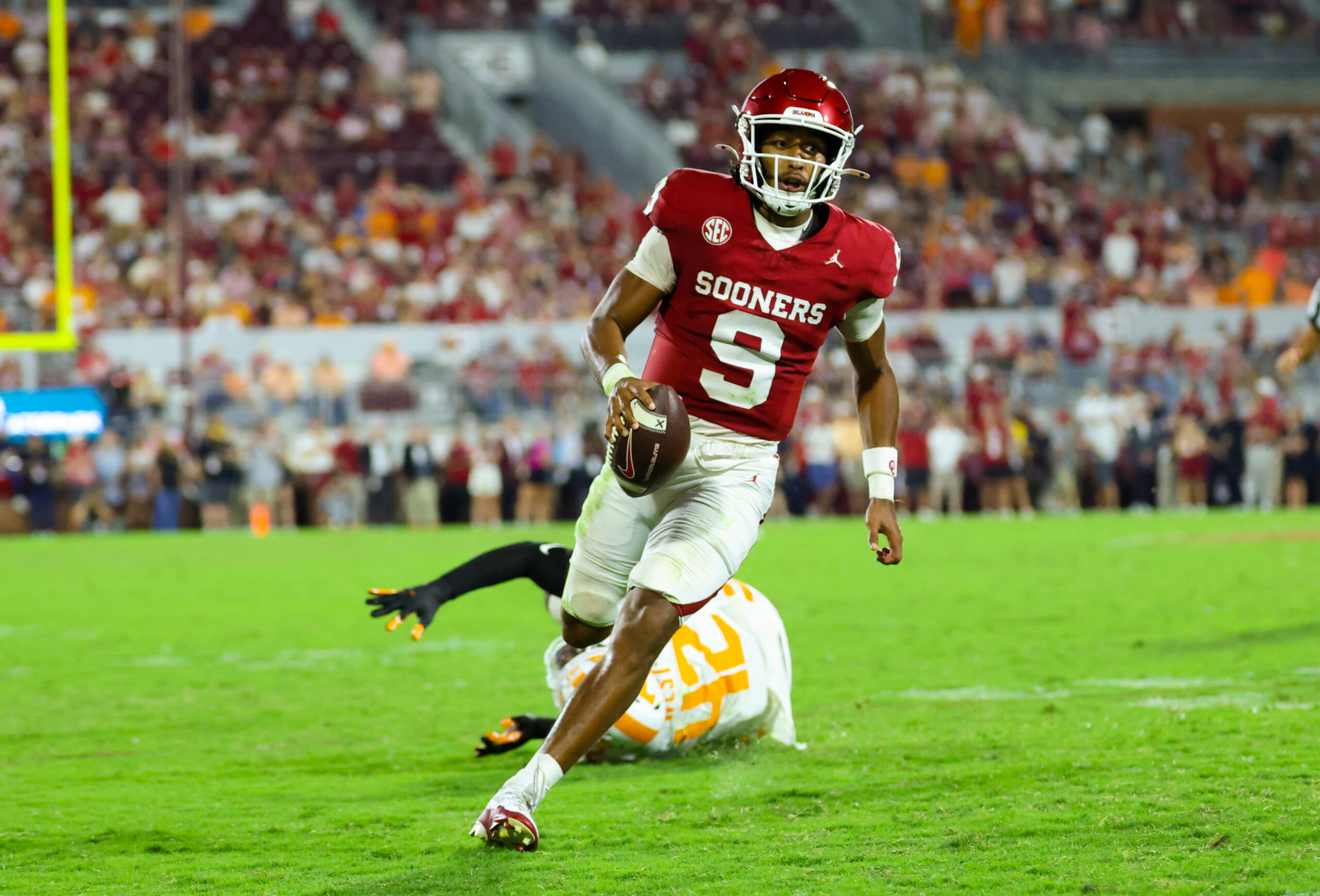 Sep 21, 2024; Norman, Oklahoma, USA; Oklahoma Sooners quarterback Michael Hawkins Jr. (9) runs past Tennessee Volunteers defensive lineman Tyre West (42) during the second half at Gaylord Family-Oklahoma Memorial Stadium.