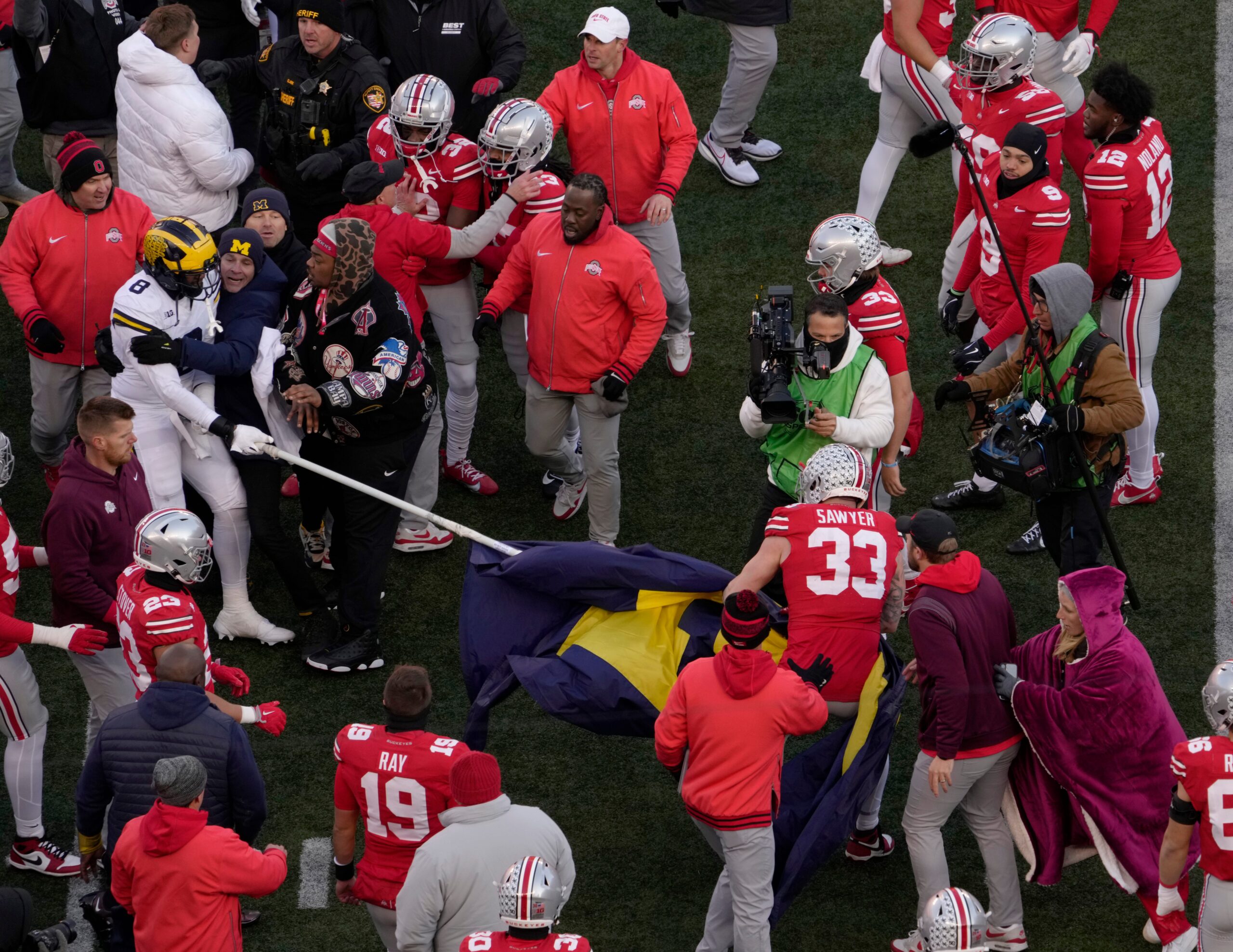 Ohio State Buckeyes defensive end Jack Sawyer (33) rips a Michigan flag away from players at midfield following Saturday’s NCAA Division I at Ohio Stadium, a 13-10 win for the Wolverines.