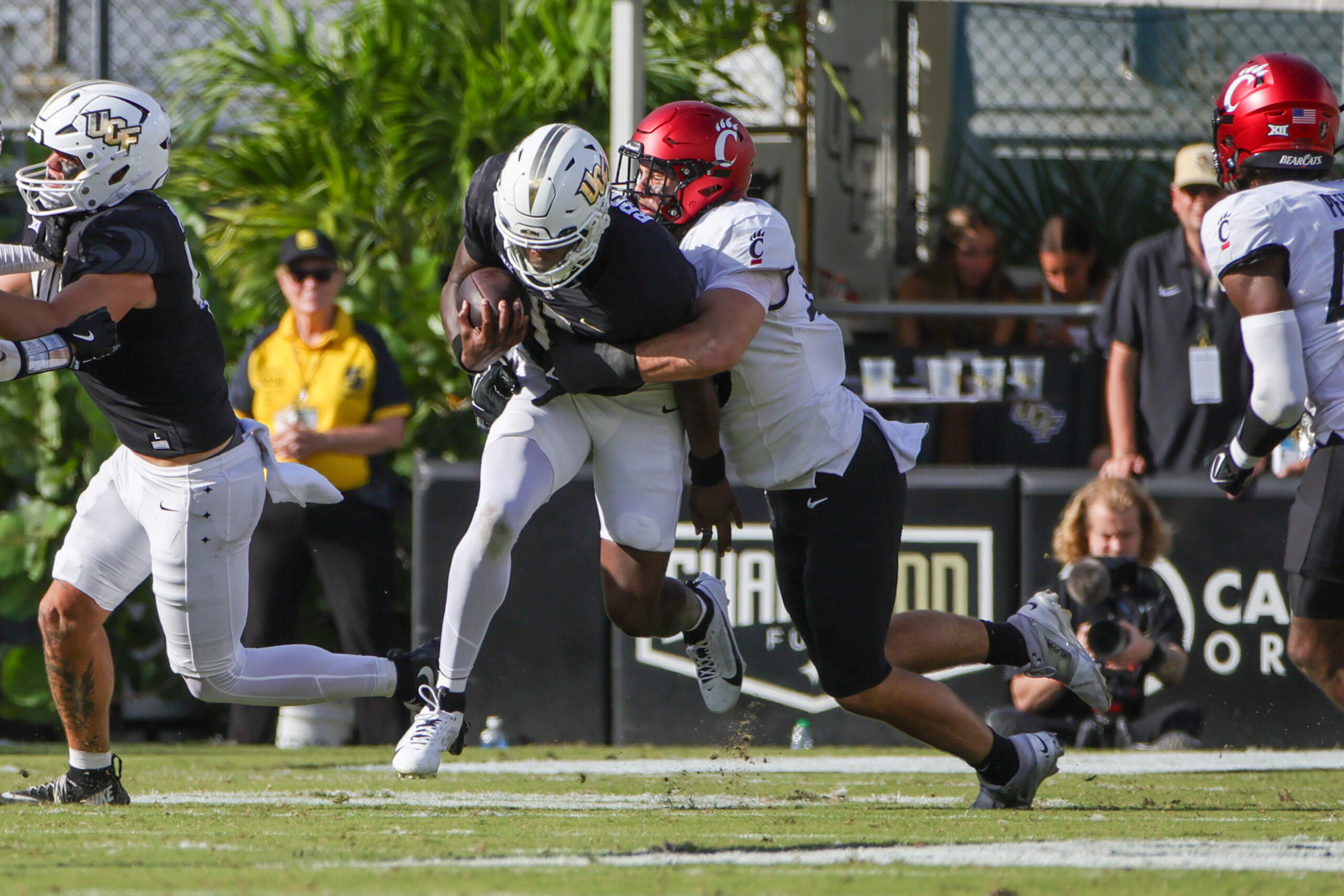 Oct 12, 2024; Orlando, Florida, USA; UCF Knights quarterback Jacurri Brown (11) is tackled by Cincinnati Bearcats linebacker Jack Dingle (49) during the second quarter at FBC Mortgage Stadium.