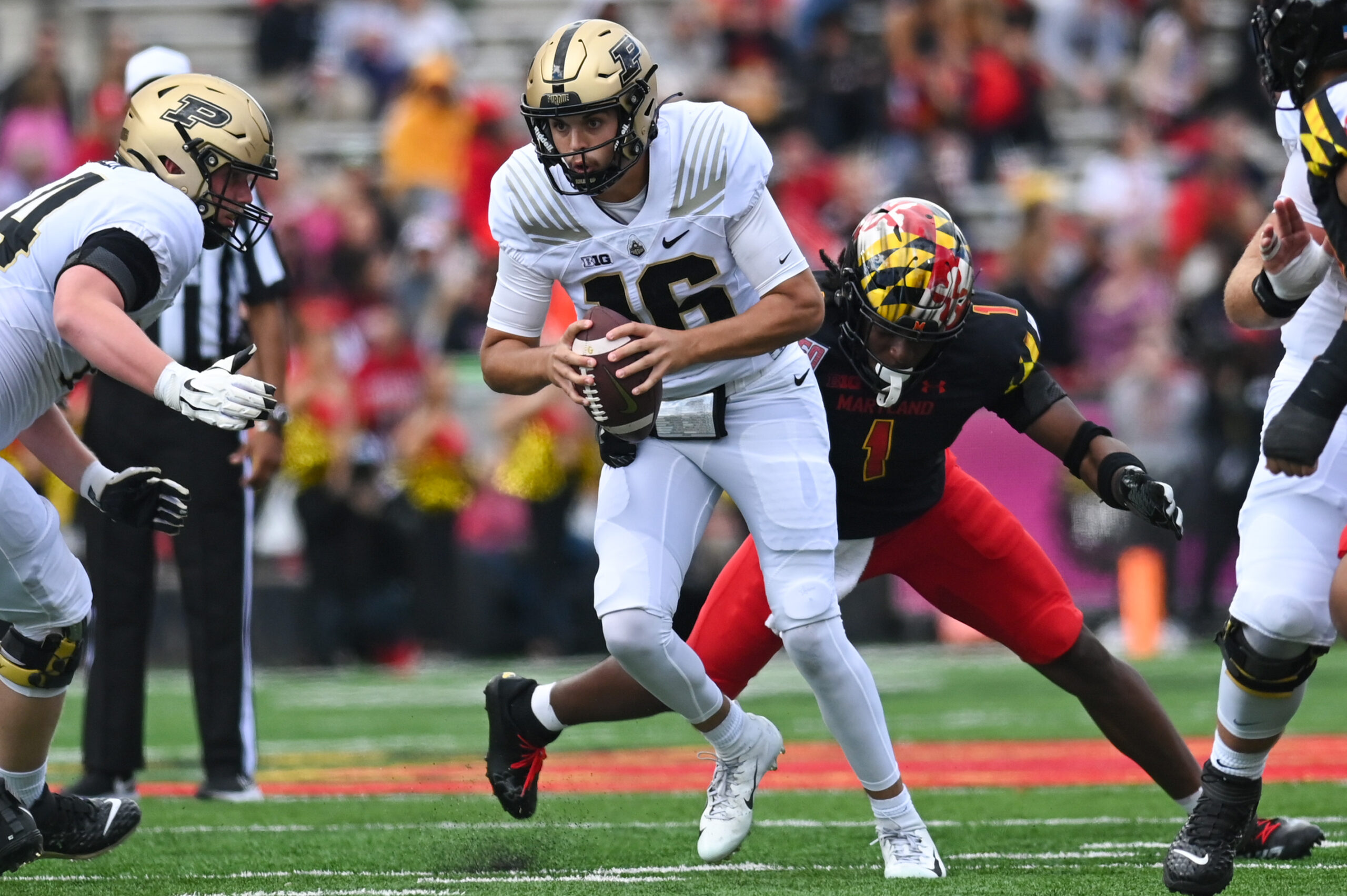 Oct 8, 2022; College Park, Maryland, USA; Purdue Boilermakers quarterback Aidan O'Connell (16) scrambles as Maryland Terrapins linebacker Jaishawn Barham (1) applies pressure during the first half at SECU Stadium.