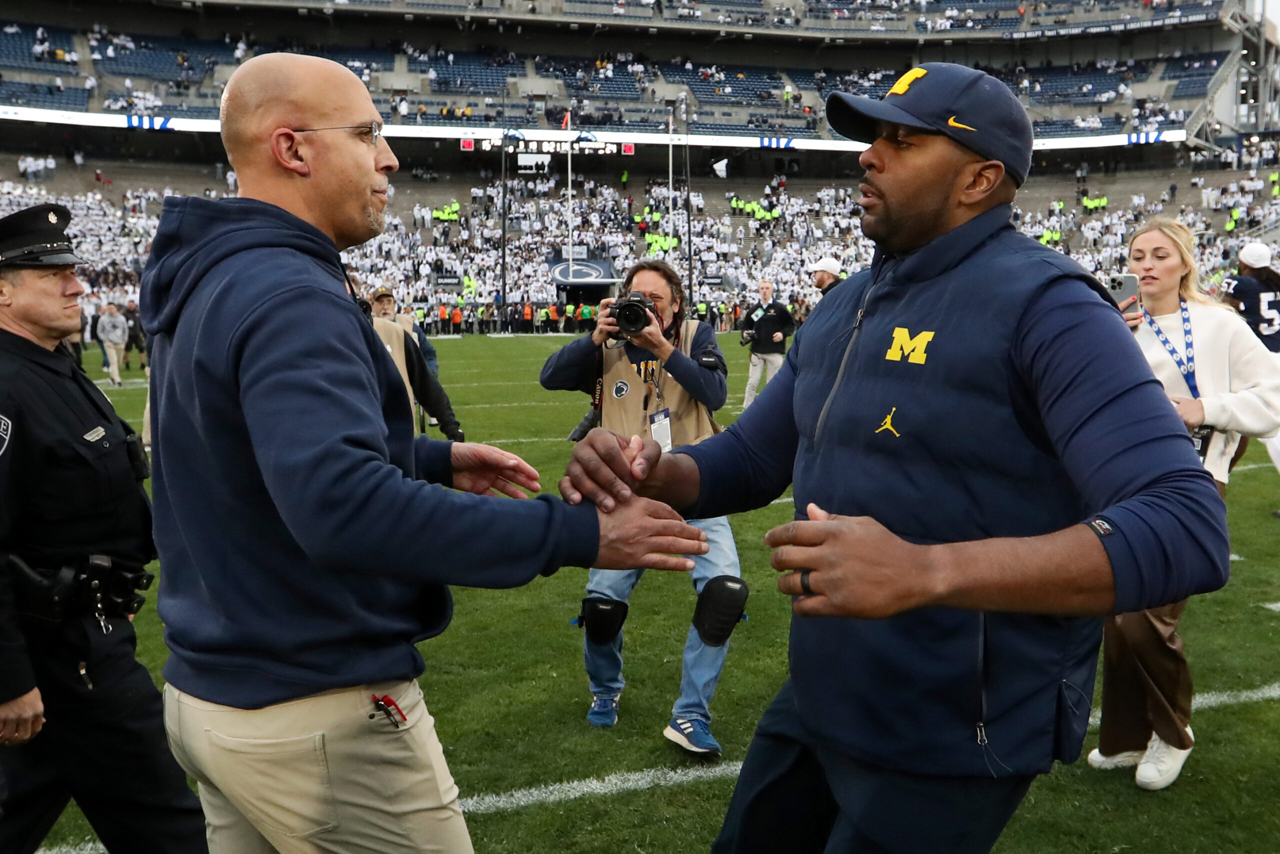 Nov 11, 2023; University Park, Pennsylvania, USA; Penn State Nittany Lions head coach James Franklin (left) shakes hands with Michigan Wolverines offensive line coach Sherrone Moore (right) following a game at Beaver Stadium. Michigan won 24-15.
