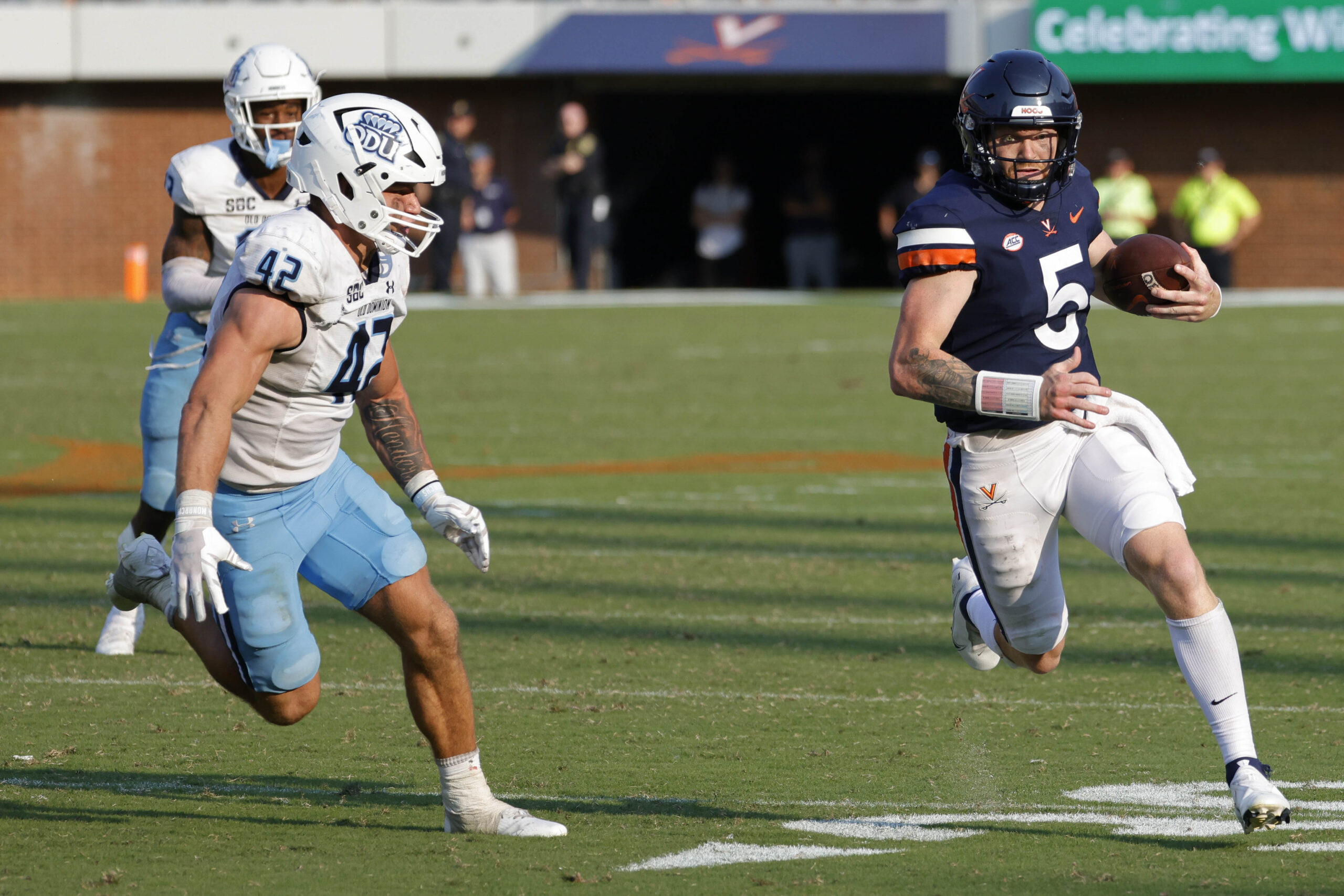 Sep 17, 2022; Charlottesville, Virginia, USA; Virginia Cavaliers quarterback Brennan Armstrong (5) runs with the ball as Old Dominion Monarchs linebacker Jason Henderson (42) chases during the fourth quarter at Scott Stadium.