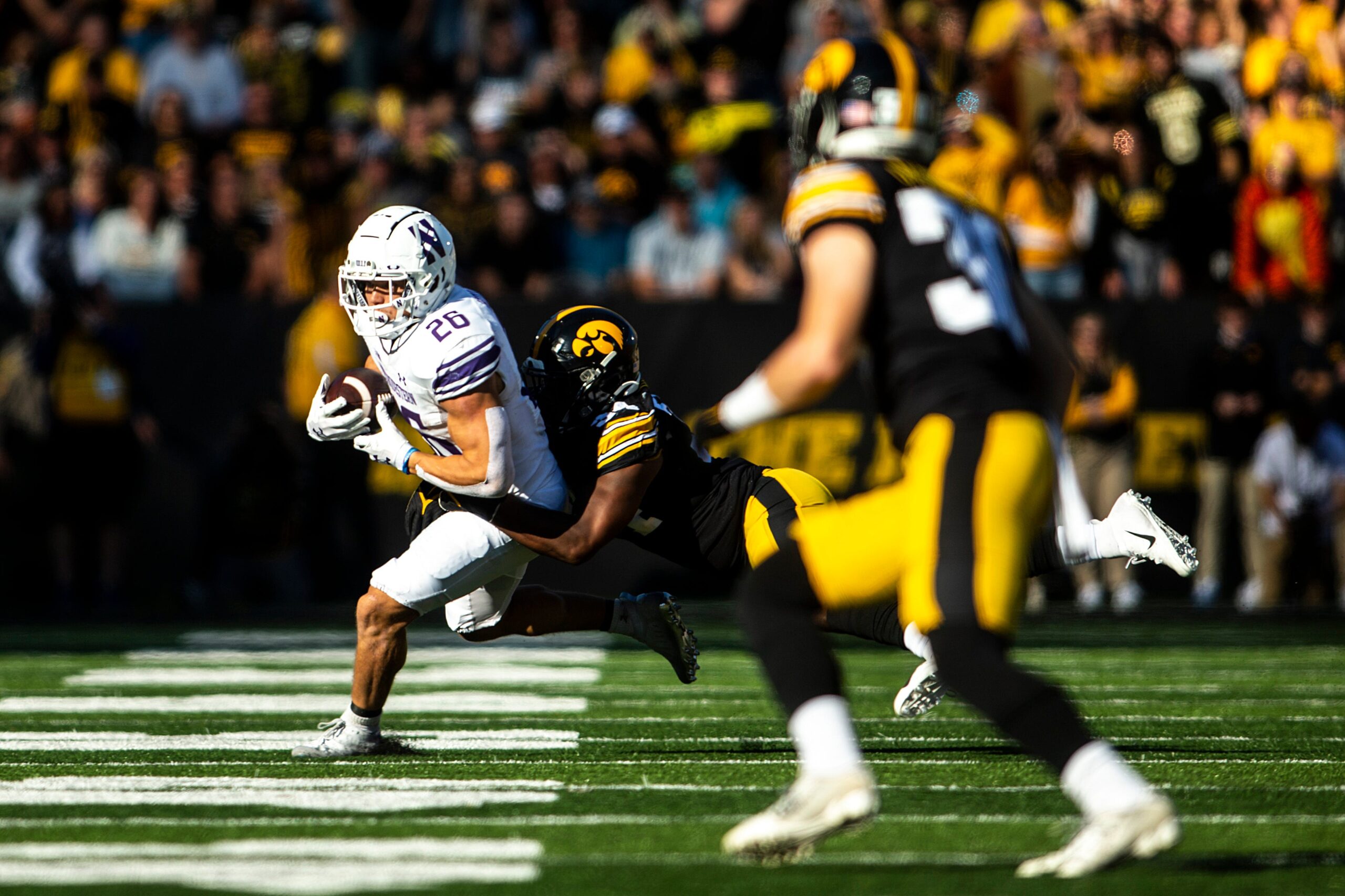 Iowa linebacker Jay Higgins (34) tackles Northwestern running back Joseph Himon II (20) during a NCAA Big Ten Conference football game, Saturday, Oct. 29, 2022, at Kinnick Stadium in Iowa City, Iowa.