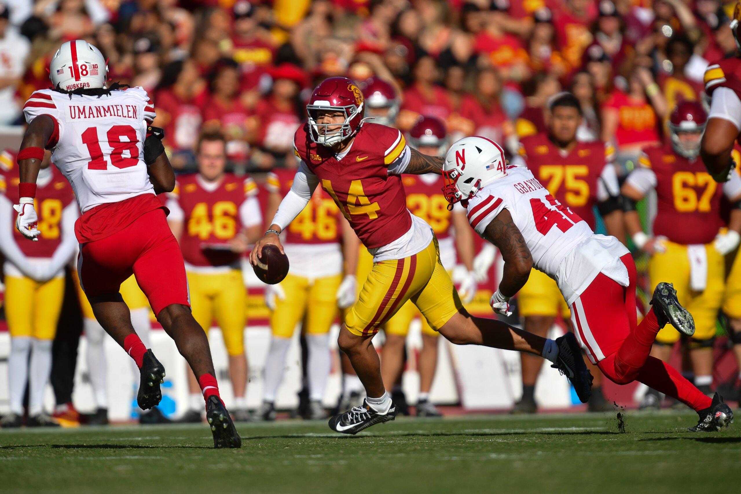 Nov 16, 2024; Los Angeles, California, USA; Southern California Trojans quarterback Jayden Maiava (14) runs the ball against Nebraska Cornhuskers linebacker Princewill Umanmielen (18) and linebacker Mikai Gbayor (42) during the first half at the Los Angeles Memorial Coliseum.