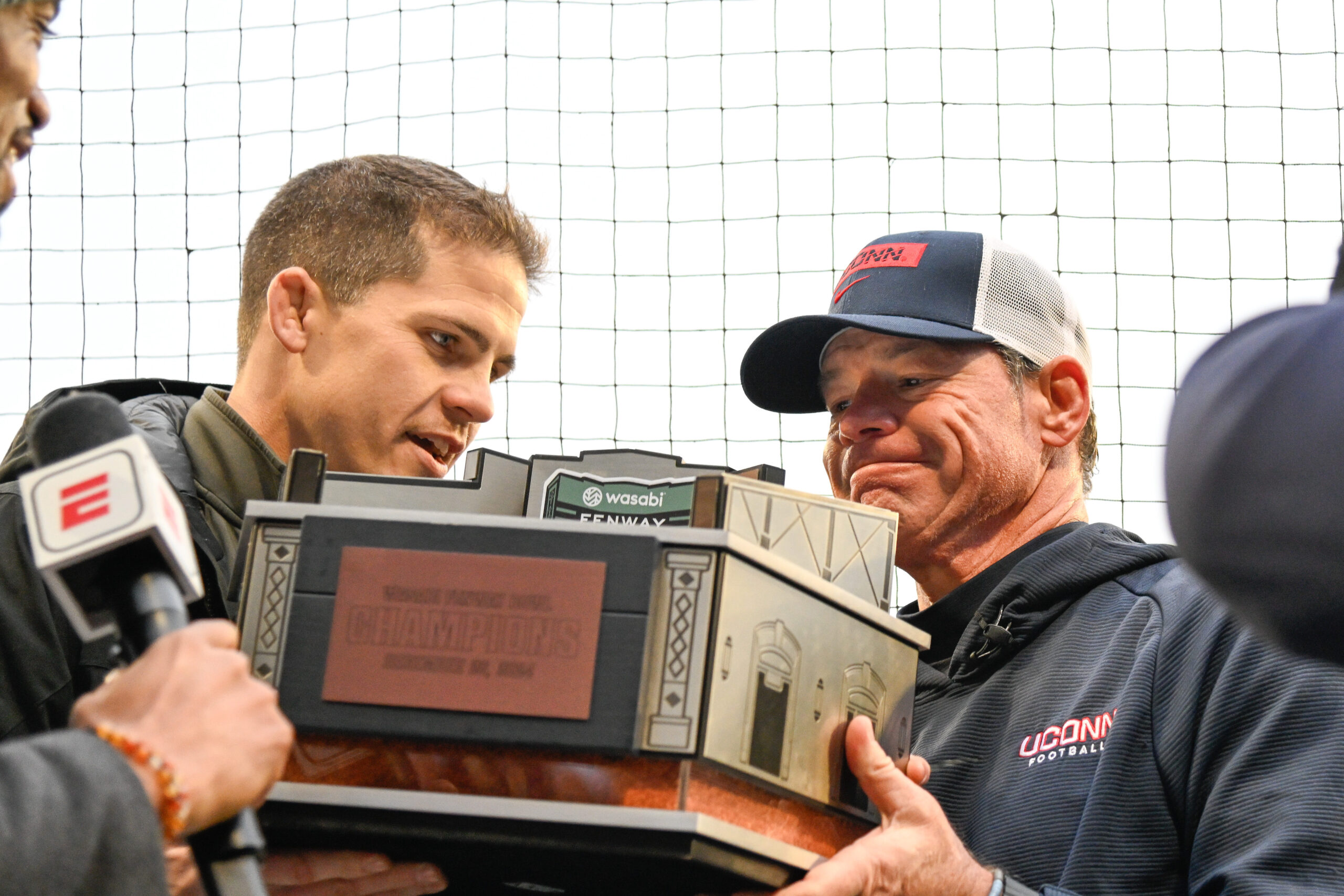 Dec 28, 2024; Boston, MA, USA; Connecticut Huskies head coach Jim Mora holds the Champions trophy after defeating the North Carolina Tar Heels in the Fenway Bowl at Fenway Park.