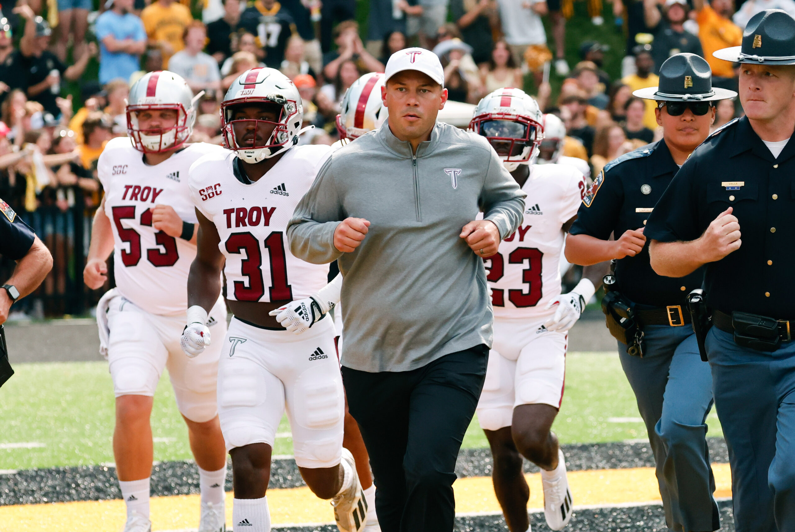 Sep 17, 2022; Boone, North Carolina, USA; Troy Trojans head coach Jon Sumrall (middle) runs on the field before the game against the Appalachian State Mountaineers at Kidd Brewer Stadium