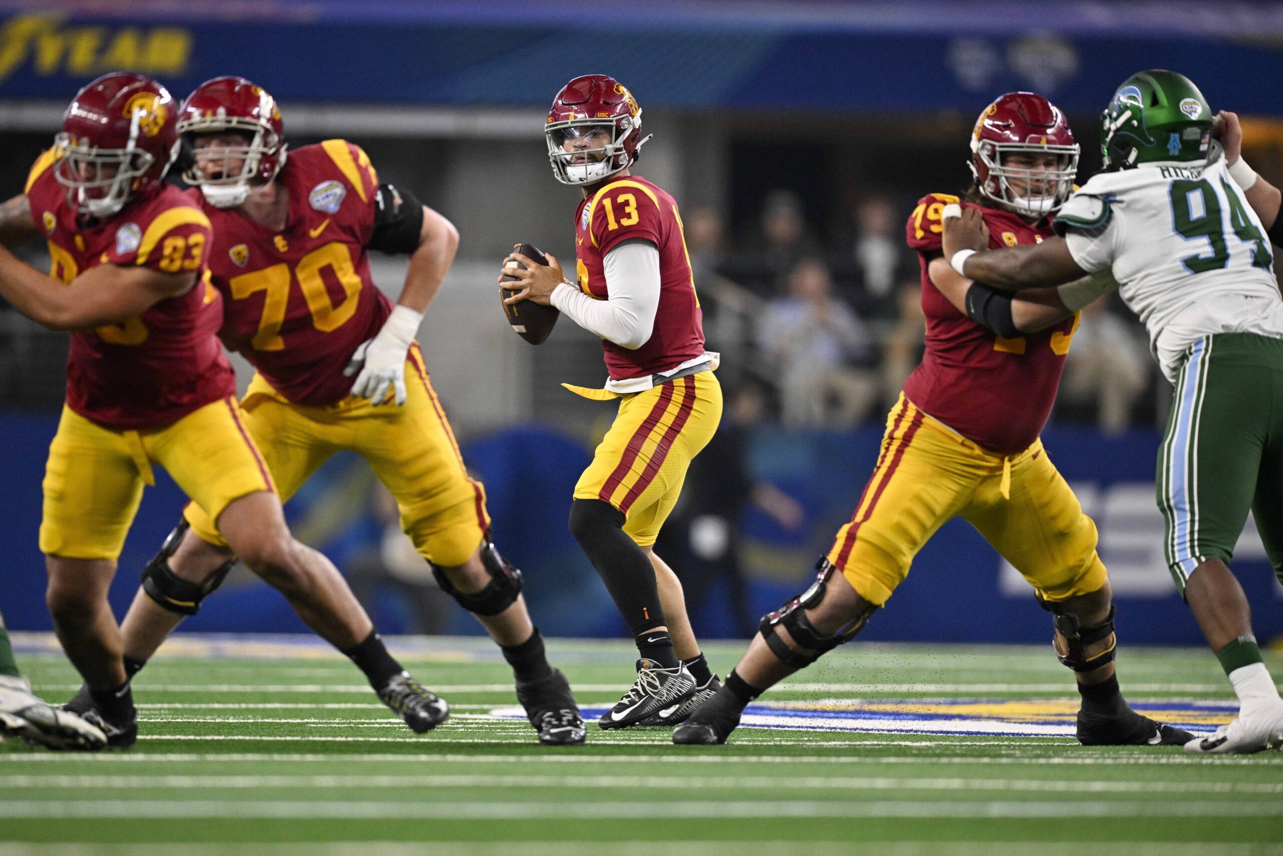 Jan 2, 2023; Arlington, Texas, USA; USC Trojans quarterback Caleb Williams (13) and offensive lineman Bobby Haskins (70) and offensive lineman Jonah Monheim (79) in action during the game between the USC Trojans and the Tulane Green Wave in the 2023 Cotton Bowl at AT&T Stadium.
