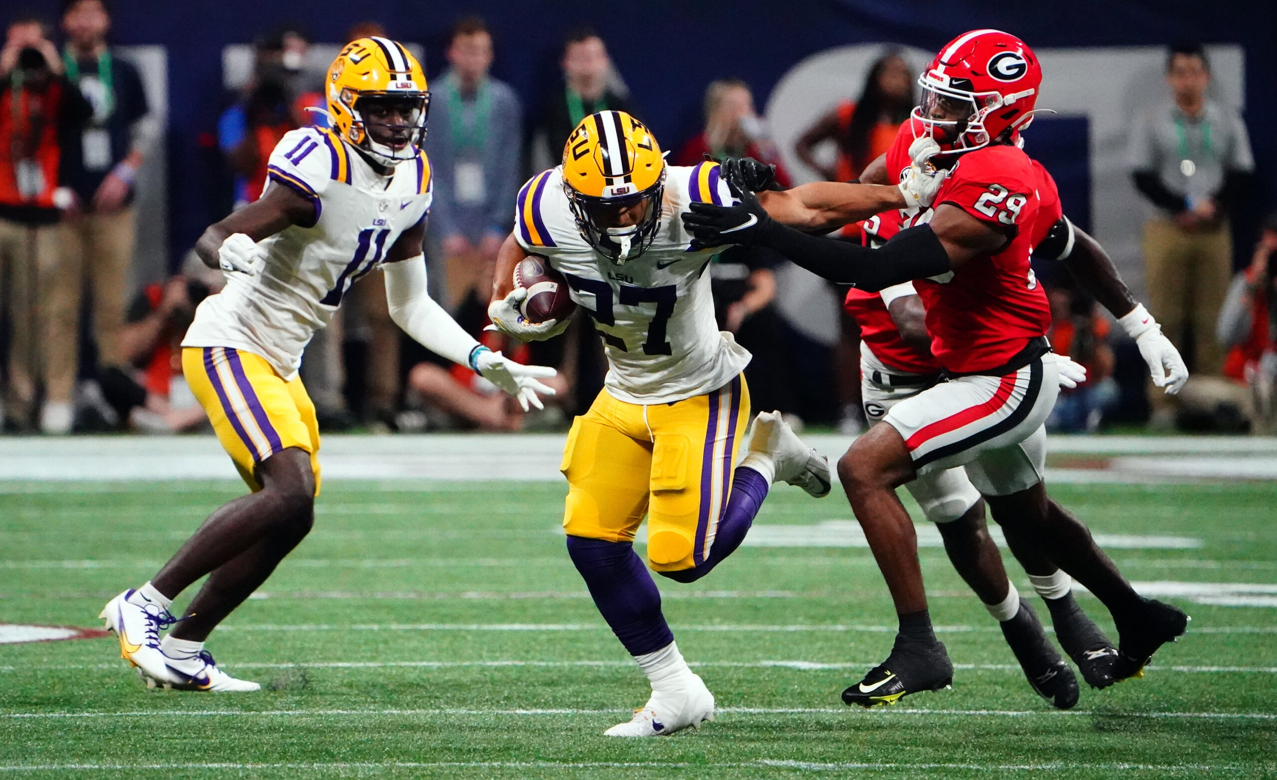 Dec 3, 2022; Atlanta, GA, USA; LSU Tigers running back Josh Williams (27) carries the ball against the Georgia Bulldogs during the first quarter of the SEC Championship game at Mercedes-Benz Stadium.