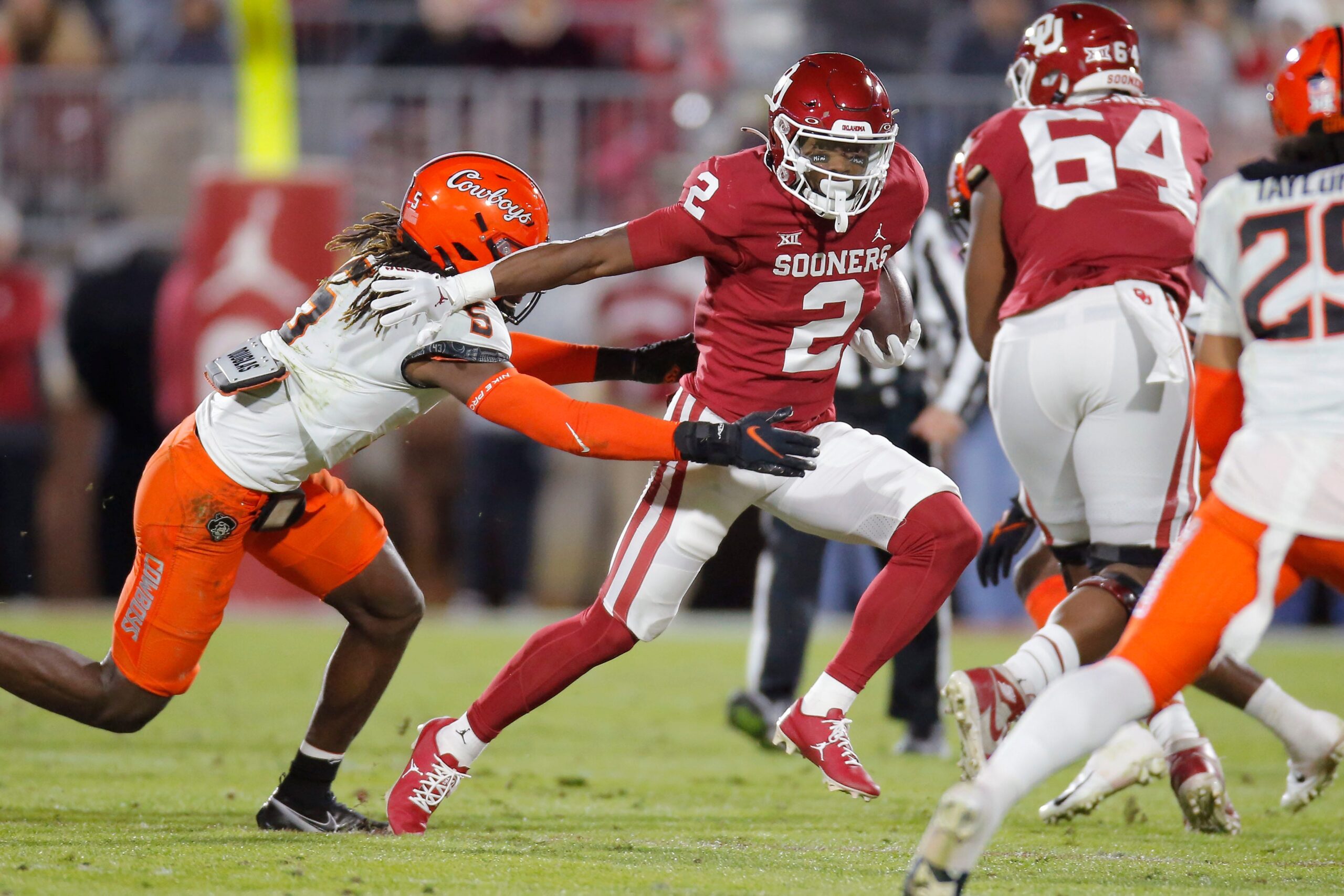 Oklahoma's Jovantae Barnes (2) runs past Oklahoma State's Kendal Daniels (5) during a Bedlam college football game between the University of Oklahoma Sooners (OU) and the Oklahoma State University Cowboys (OSU) at Gaylord Family-Oklahoma Memorial Stadium in Norman, Okla., Saturday, Nov. 19, 2022.