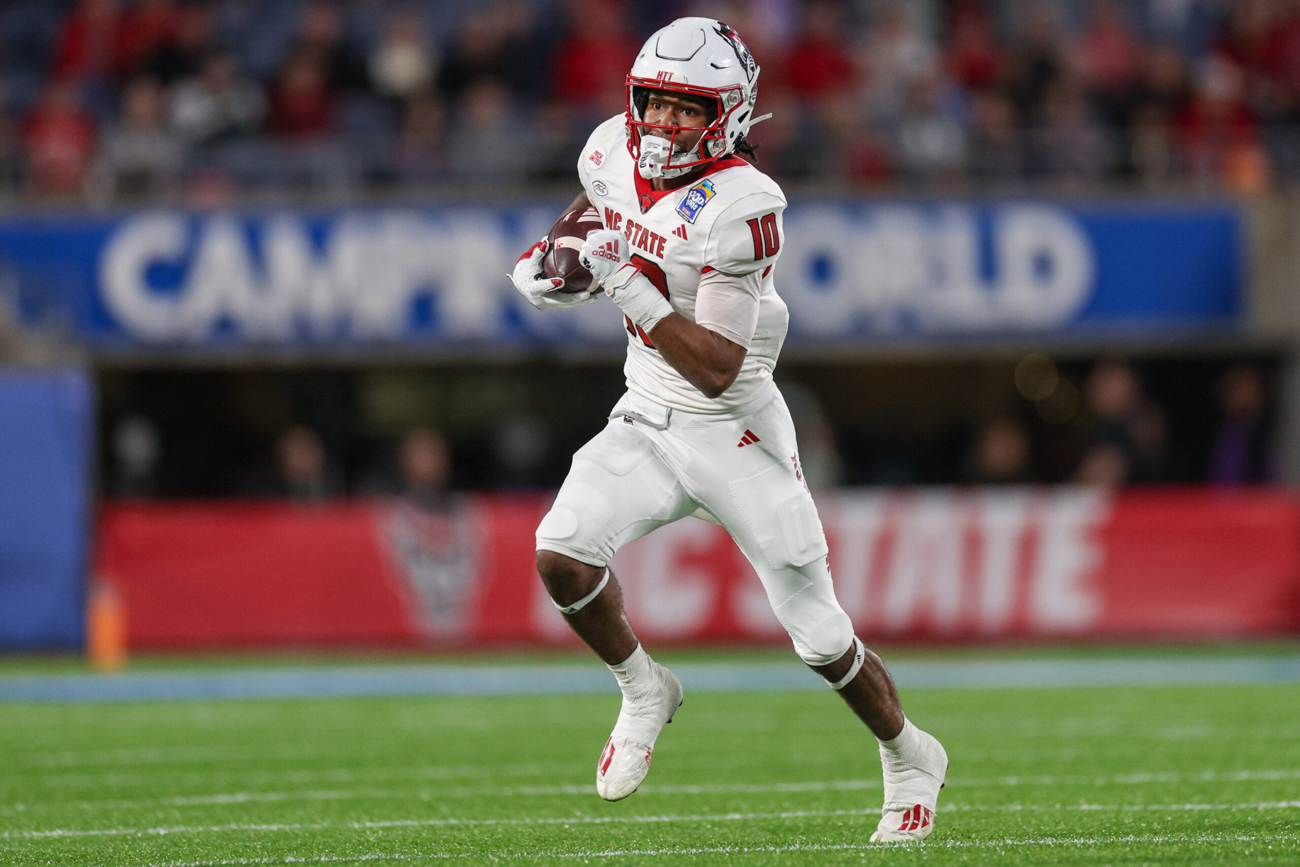 Dec 28, 2023; Orlando, FL, USA; North Carolina State Wolfpack wide receiver Kevin Concepcion (10) runs with the ball against the Kansas State Wildcats in the second quarter during the Pop-Tarts bowl at Camping World Stadium.