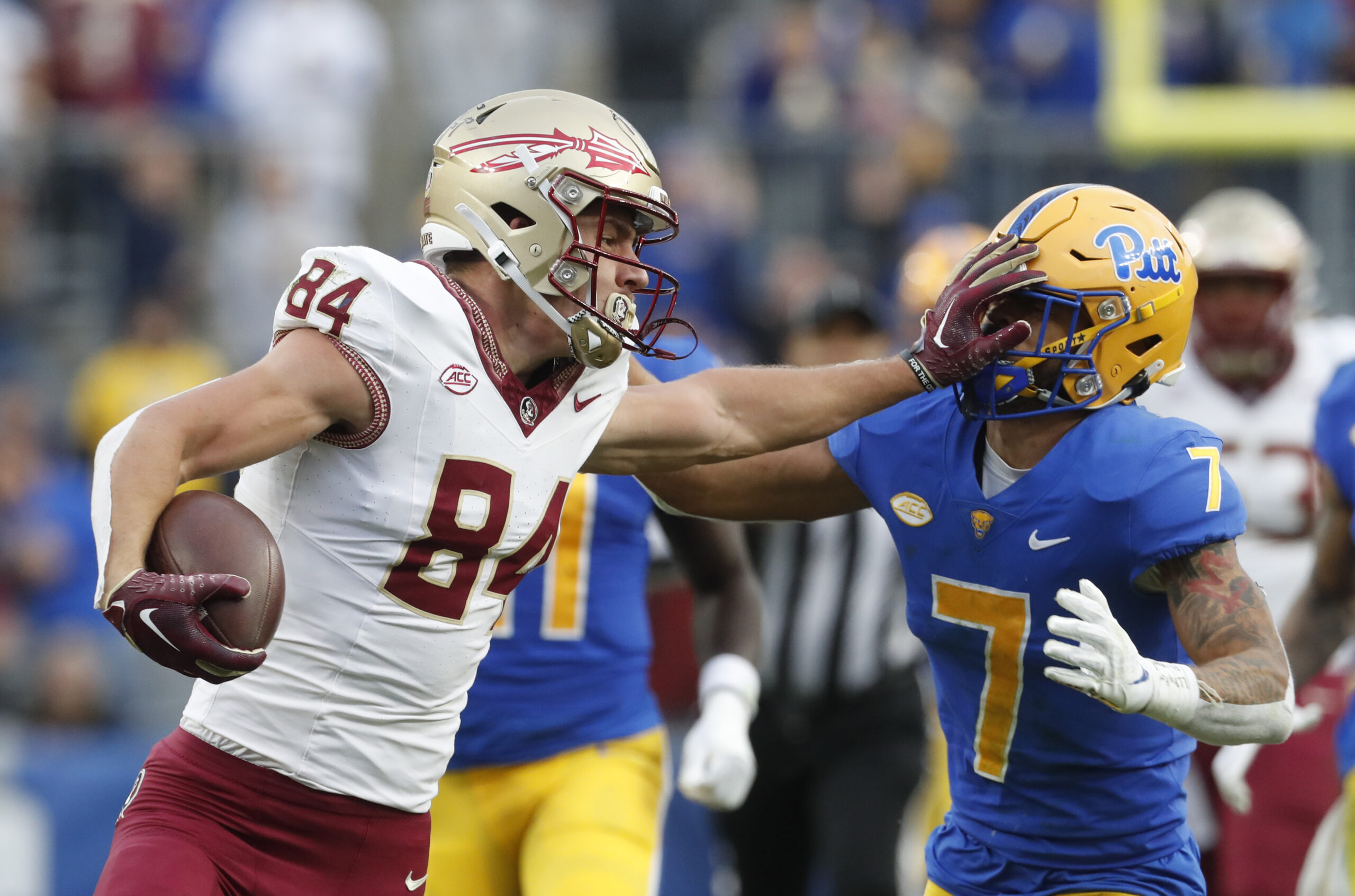 Nov 4, 2023; Pittsburgh, Pennsylvania, USA; Florida State Seminoles tight end Kyle Morlock (84) stiff arms Pittsburgh Panthers defensive back Javon McIntyre (7) after a catch during the second quarter at Acrisure Stadium