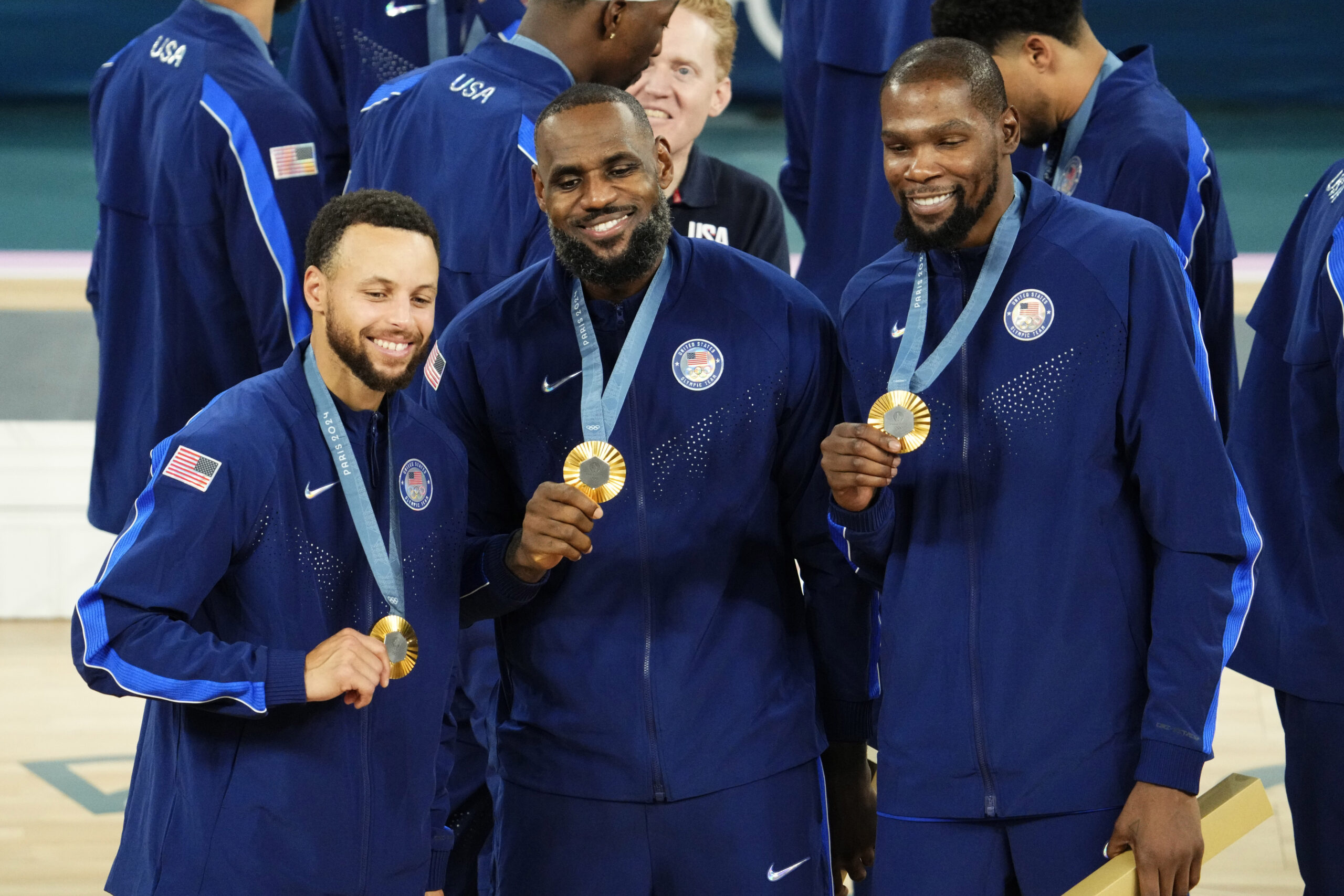 Aug 10, 2024; Paris, France; United States shooting guard Stephen Curry (4) and guard LeBron James (6) and guard Kevin Durant (7) celebrate with their gold medals on the podium after defeating France in the men's basketball gold medal game during the Paris 2024 Olympic Summer Games at Accor Arena. 