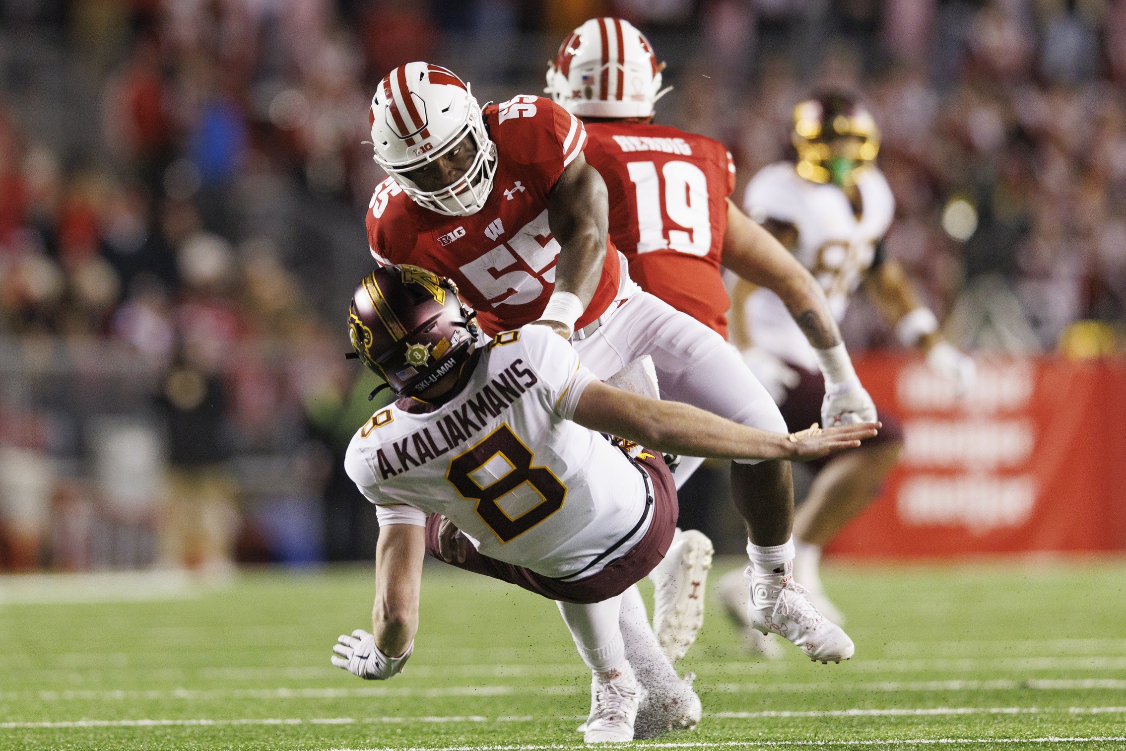 Nov 26, 2022; Madison, Wisconsin, USA; Wisconsin Badgers linebacker Maema Njongmeta (55) commits a penalty on Minnesota Golden Gophers quarterback Athan Kaliakmanis (8) during the fourth quarter at Camp Randall Stadium.