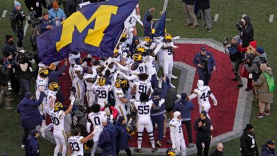 Michigan football players plant their team’s flag at midfield following Saturday’s NCAA Division I football game against the Ohio State Buckeyes at Ohio Stadium. The Michigan Wolverines won the game 13-10.