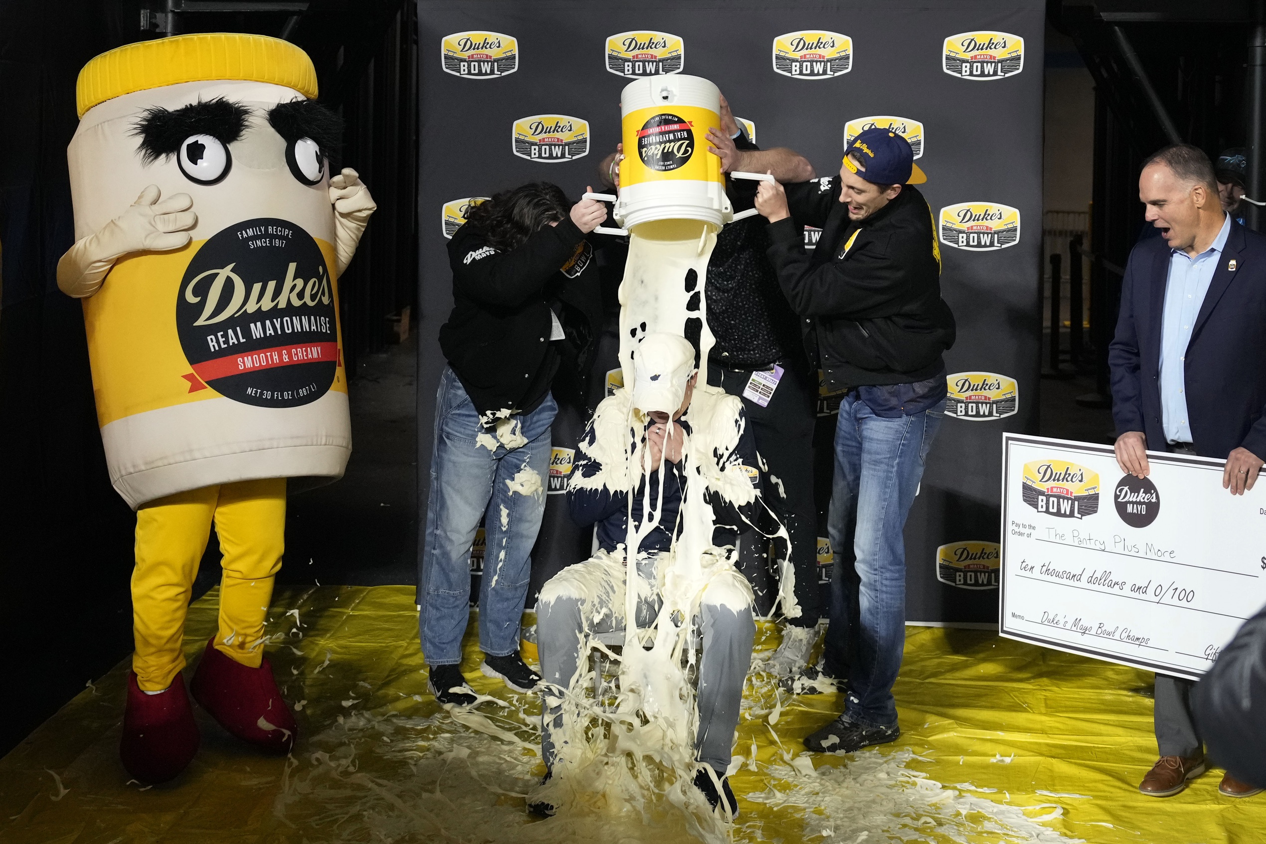 Dec 27, 2023; Charlotte, NC, USA; West Virginia Mountaineers head coach Neal Brown gets covered in mayonnaise after the game at Bank of America Stadium.