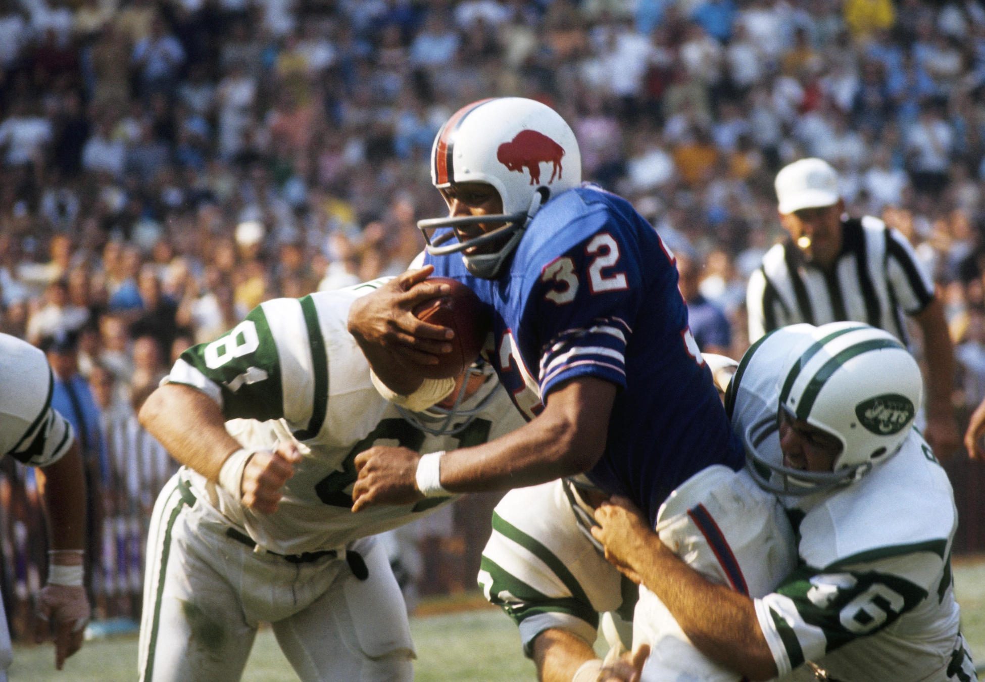 Sep 14, 1969; Buffalo, NY, USA; FILE PHOTO; Buffalo Bills running back O.J. Simpson (32) is tackled by New York Jets defensive back Bill Baird (46) and Gerry Philbin (81) at War Memorial Stadium. The Jets defeated the Bills 33-19.