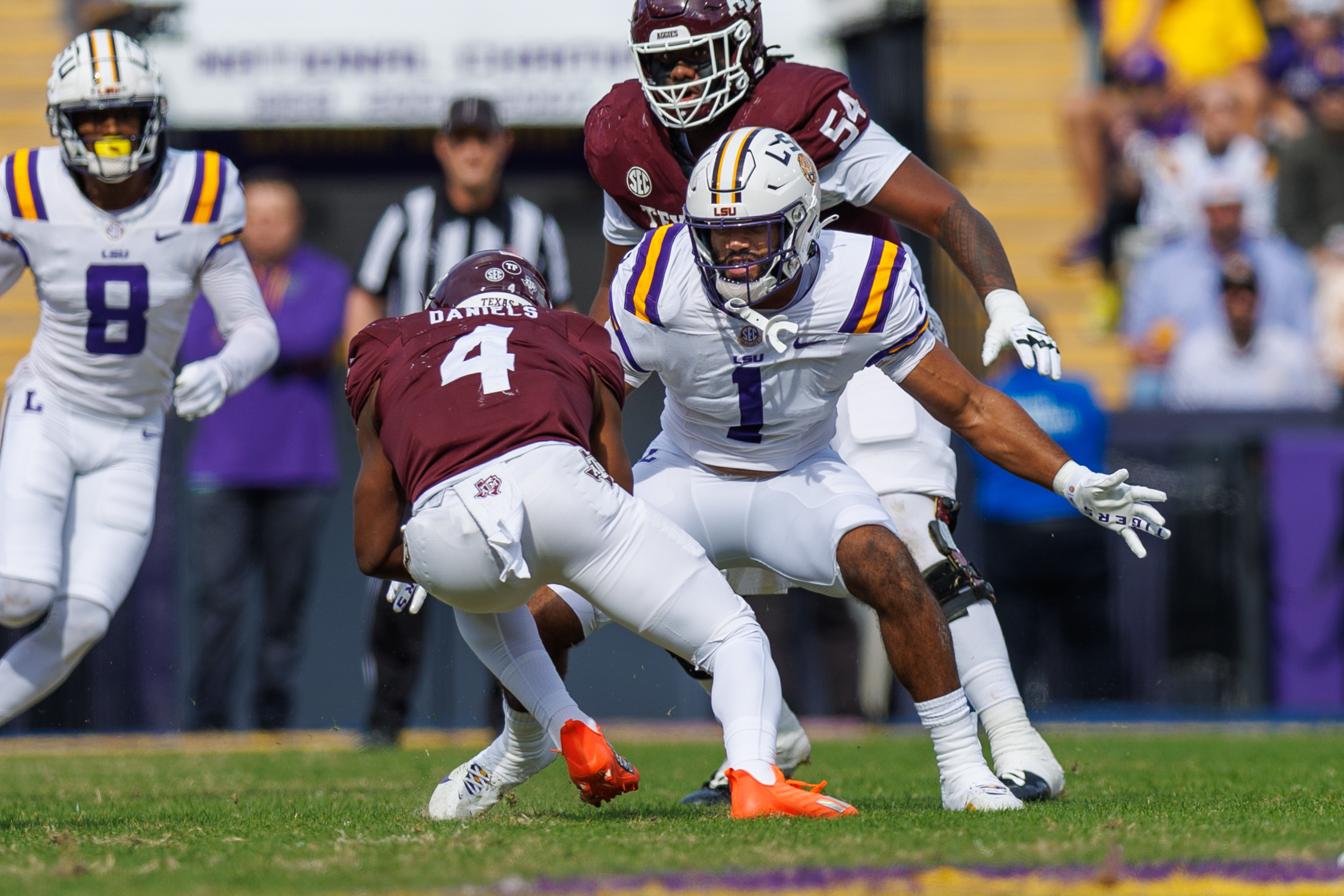 Nov 25, 2023; Baton Rouge, Louisiana, USA; Texas A&M Aggies running back Amari Daniels (4) is tacked by LSU Tigers linebacker Omar Speights (1) during the first half at Tiger Stadium.