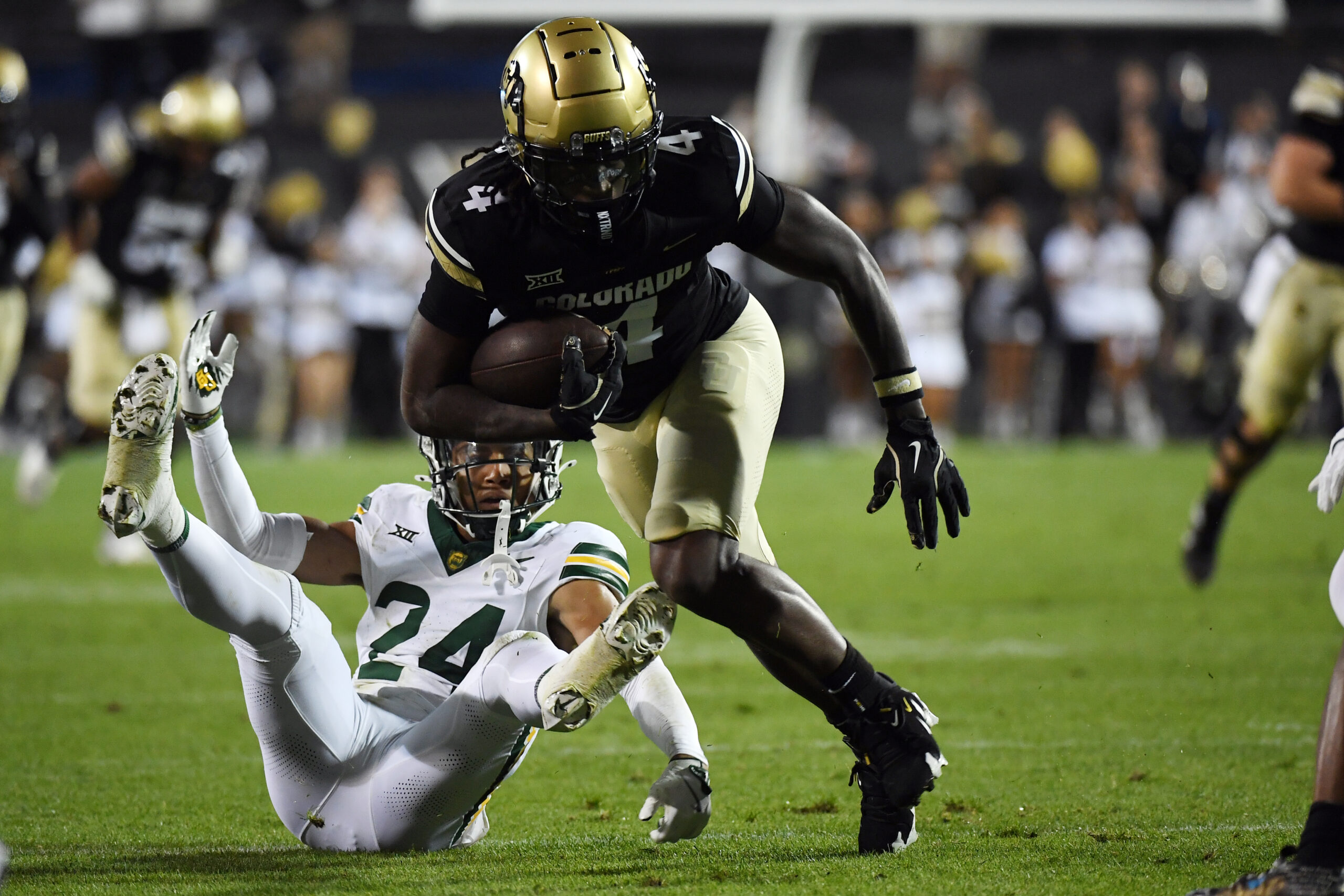 Sep 21, 2024; Boulder, Colorado, USA; Colorado Buffaloes wide receiver Omarion Miller (4) stays on his feet to score after a tackle attempt from Baylor Bears safety Corey Gordon Jr. (24) during the first half at Folsom Field.