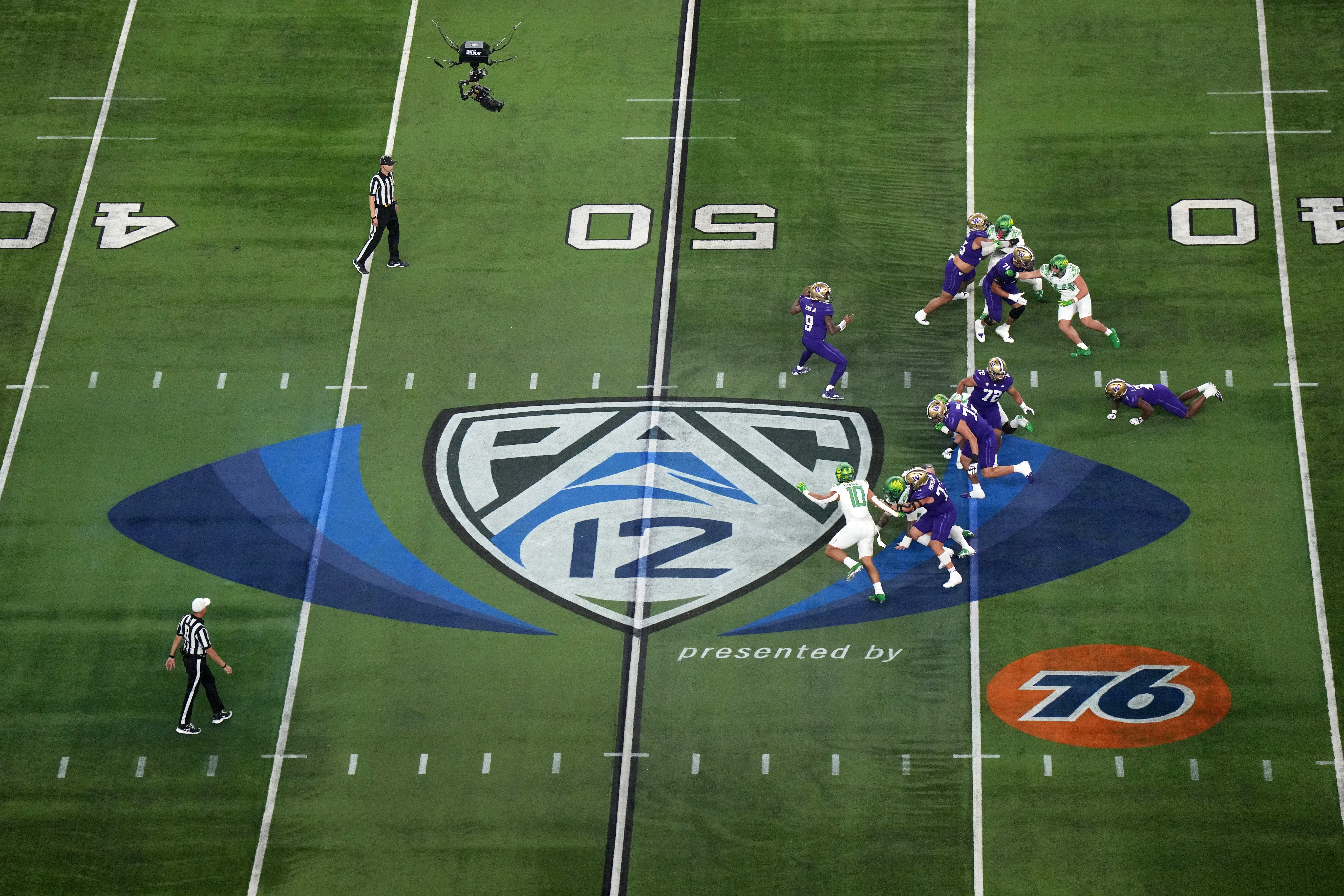 Dec 1, 2023; Las Vegas, NV, USA; A general overall view as Washington Huskies quarterback Michael Penix Jr. (9)] throws the ball at midfield on the Pac-12 Conference logo against the Oregon Ducks in the first half at Allegiant Stadium.