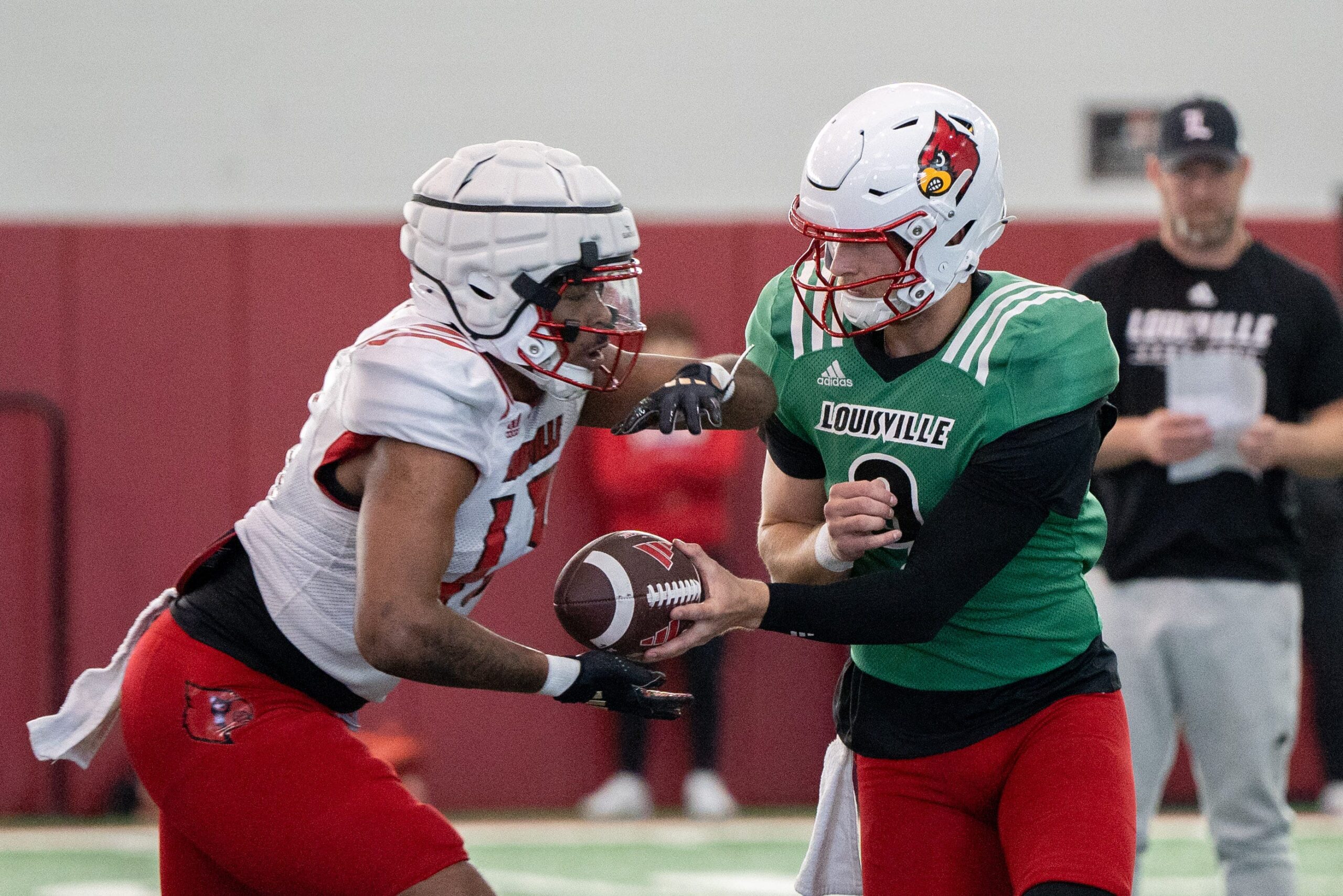 Louisville football quarterback Tyler Shough (9) and running back Peny Boone (13) run drills during spring practice on Saturday, March 23, 2024 at the Trager practice facility in Louisville, Ky.