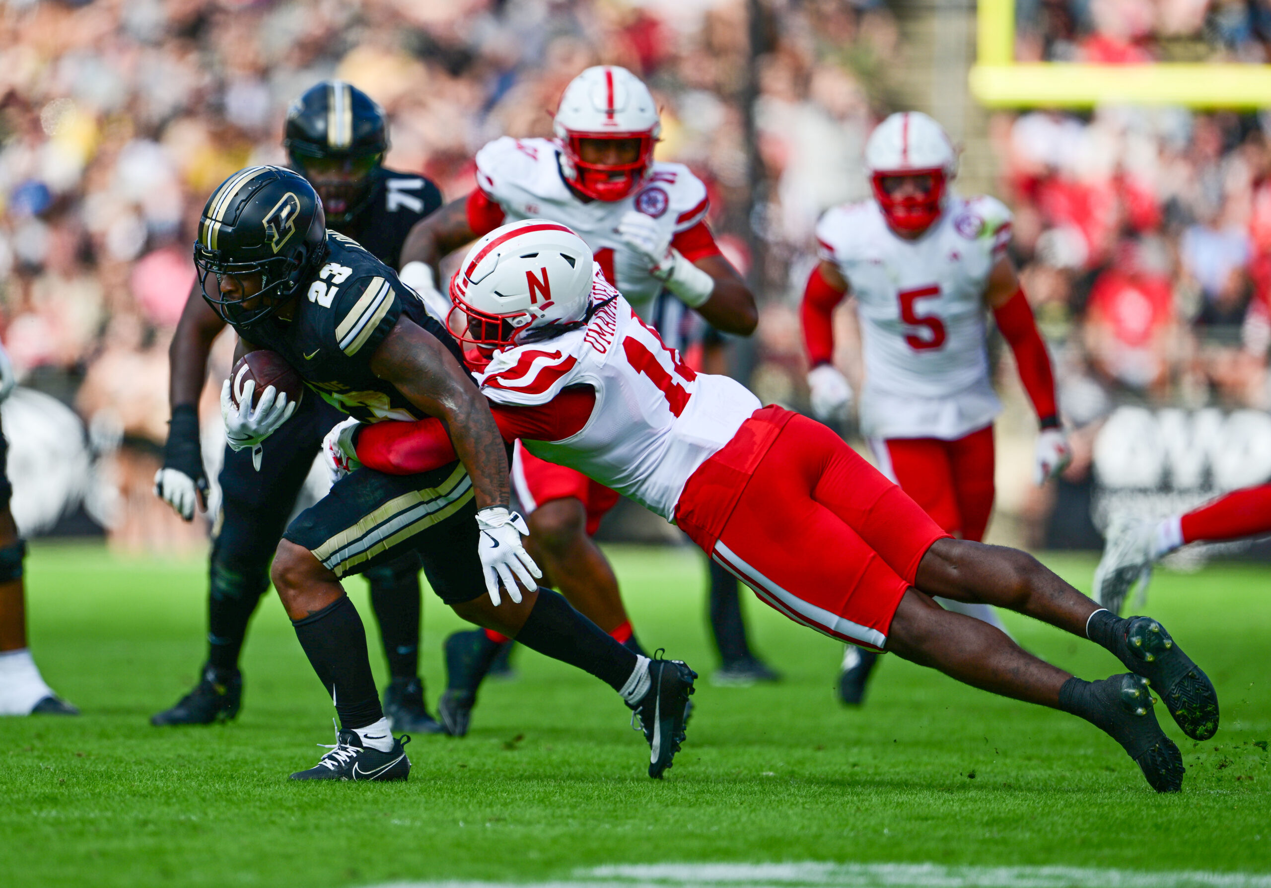 Sep 28, 2024; West Lafayette, Indiana, USA; Purdue Boilermakers running back Reggie Love III (23) is tackled by Nebraska Cornhuskers linebacker Princewill Umanmielen (18) during the second half at Ross-Ade Stadium.