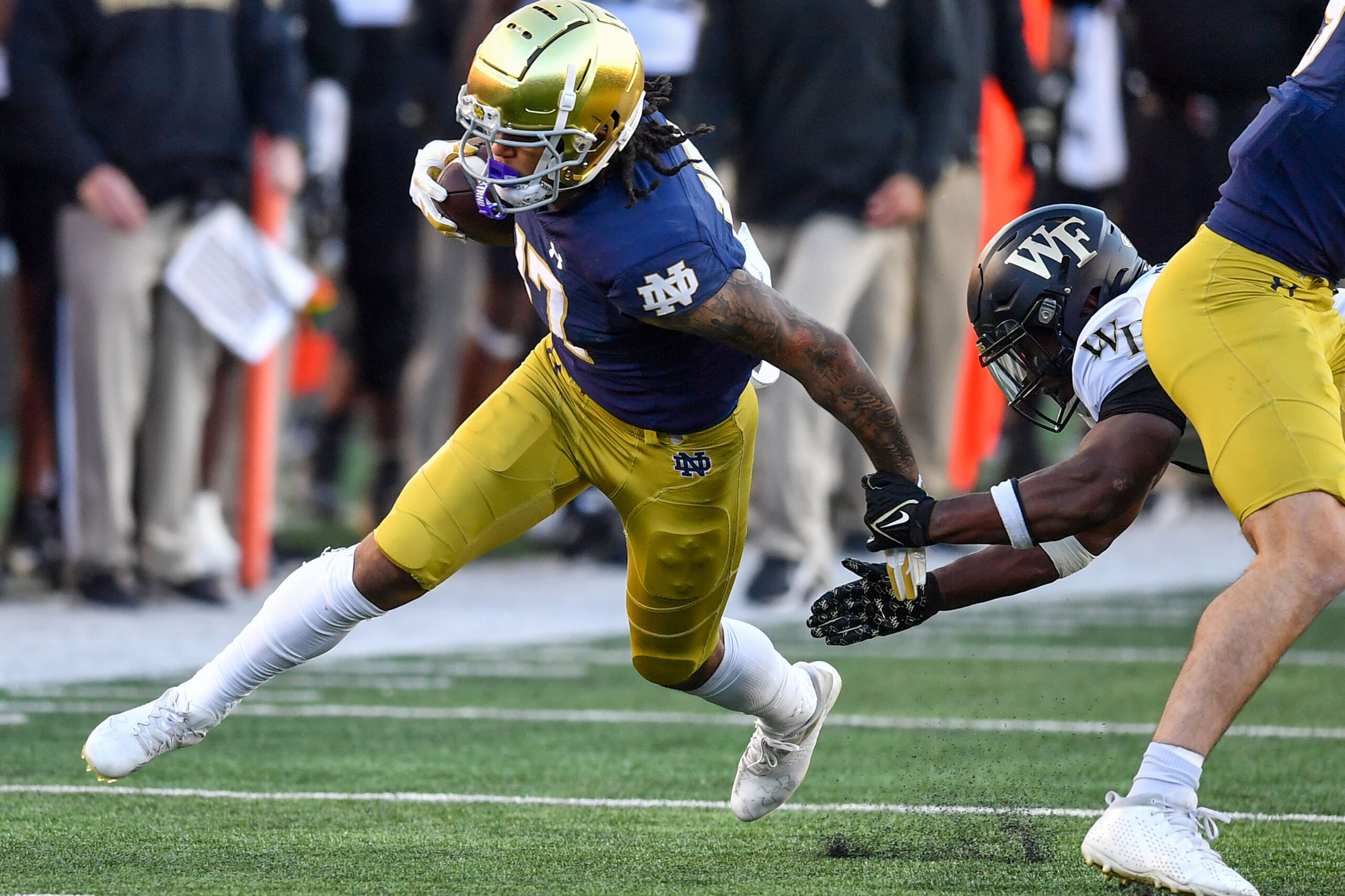 Nov 18, 2023; South Bend, Indiana, USA; Notre Dame Fighting Irish wide receiver Rico Flores Jr. (17) runs after the catch as Wake Forest Demon Deacons safety Chelen Garnes (9) defends in the second quarter at Notre Dame Stadium.