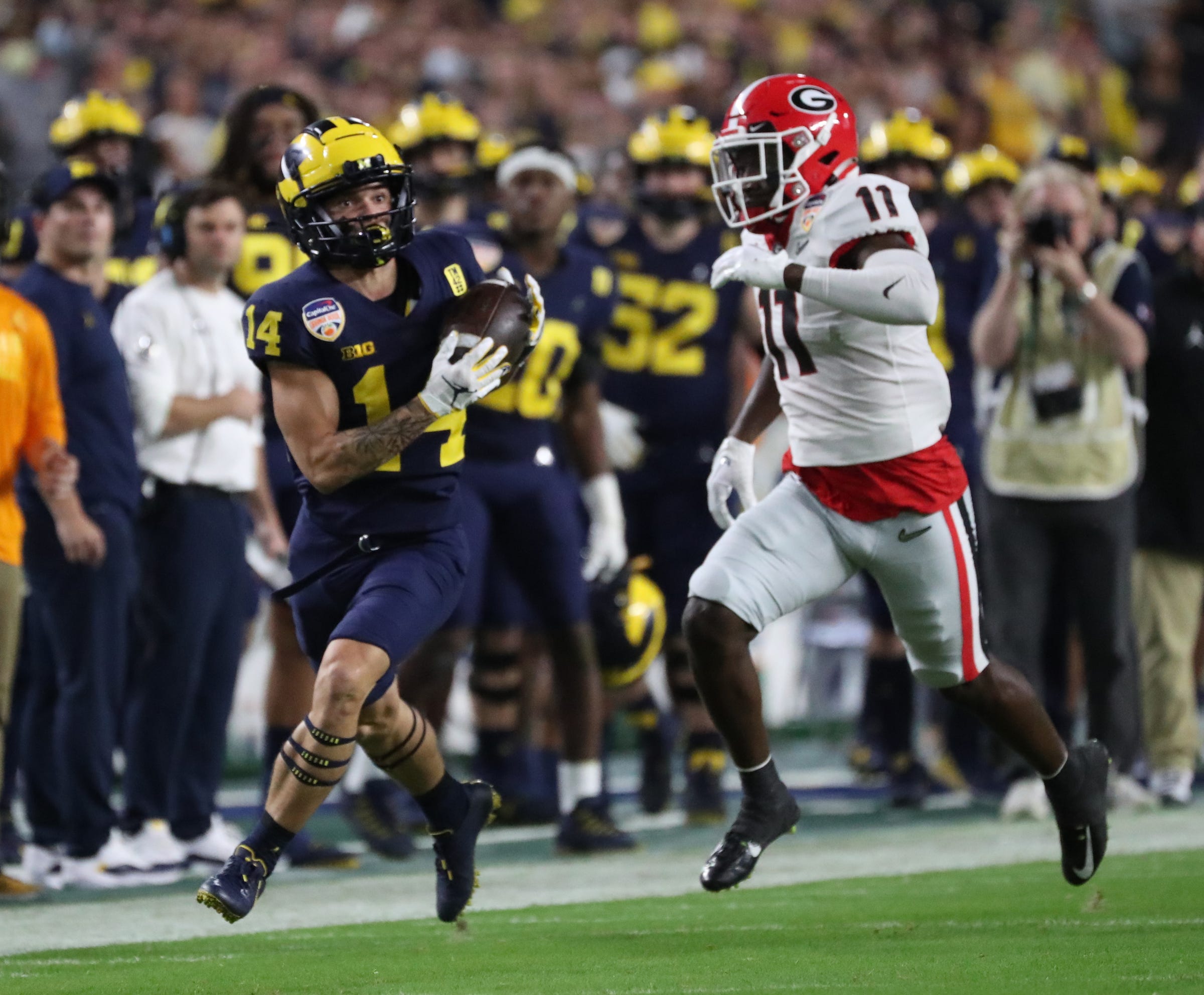 Michigan Wolverines wide receiver Roman Wilson (14) catches a pass against Georgia Bulldogs defensive back Derion Kendrick (11) during first half of the Capital One Orange Bowl game Friday, Dec. 31, 2021, at Hard Rock Stadium.
