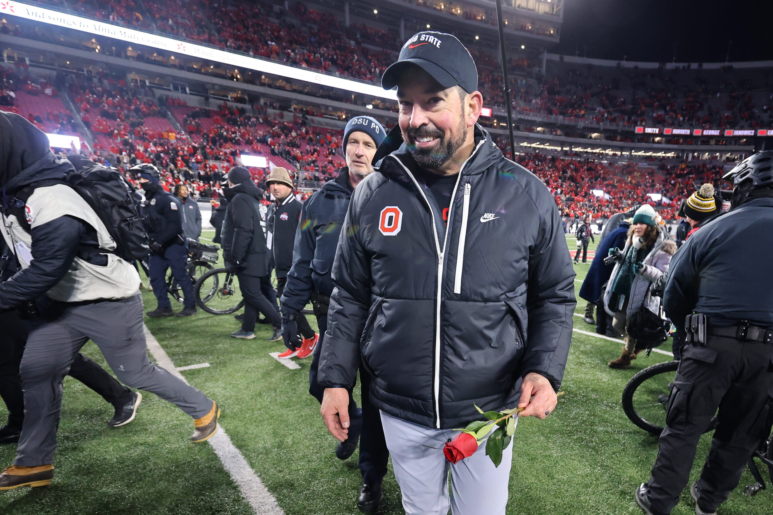 Dec 21, 2024; Columbus, Ohio, USA; Ohio State Buckeyes head coach Ryan Day celebrates the win as he carries a rose after the game against the Tennessee Volunteers at Ohio Stadium.