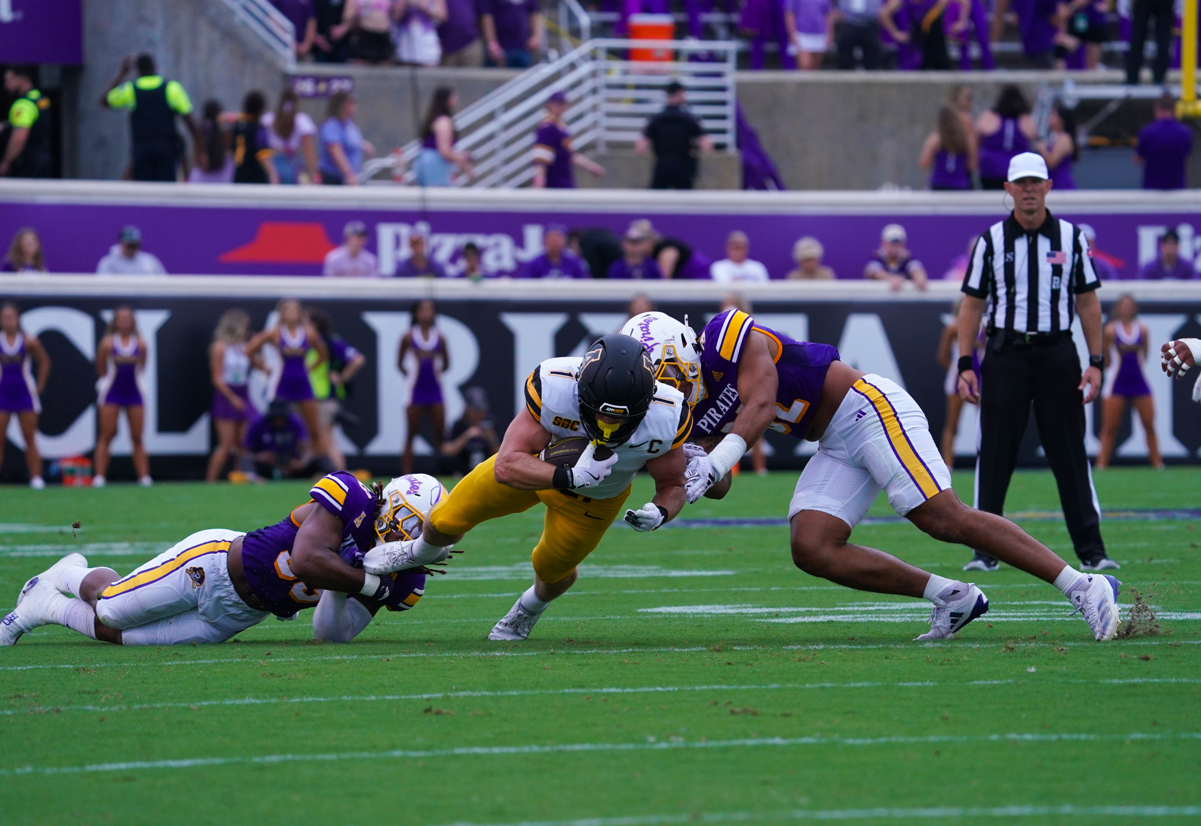 Sep 14, 2024; Greenville, North Carolina, USA; Appalachian State Mountaineers running back Anderson Castle (1) is stoped on his run by East Carolina Pirates linebacker Kevon Merrell (31) and linebacker Ryheem Craig (32) during the first half at Dowdy-Ficklen Stadium.