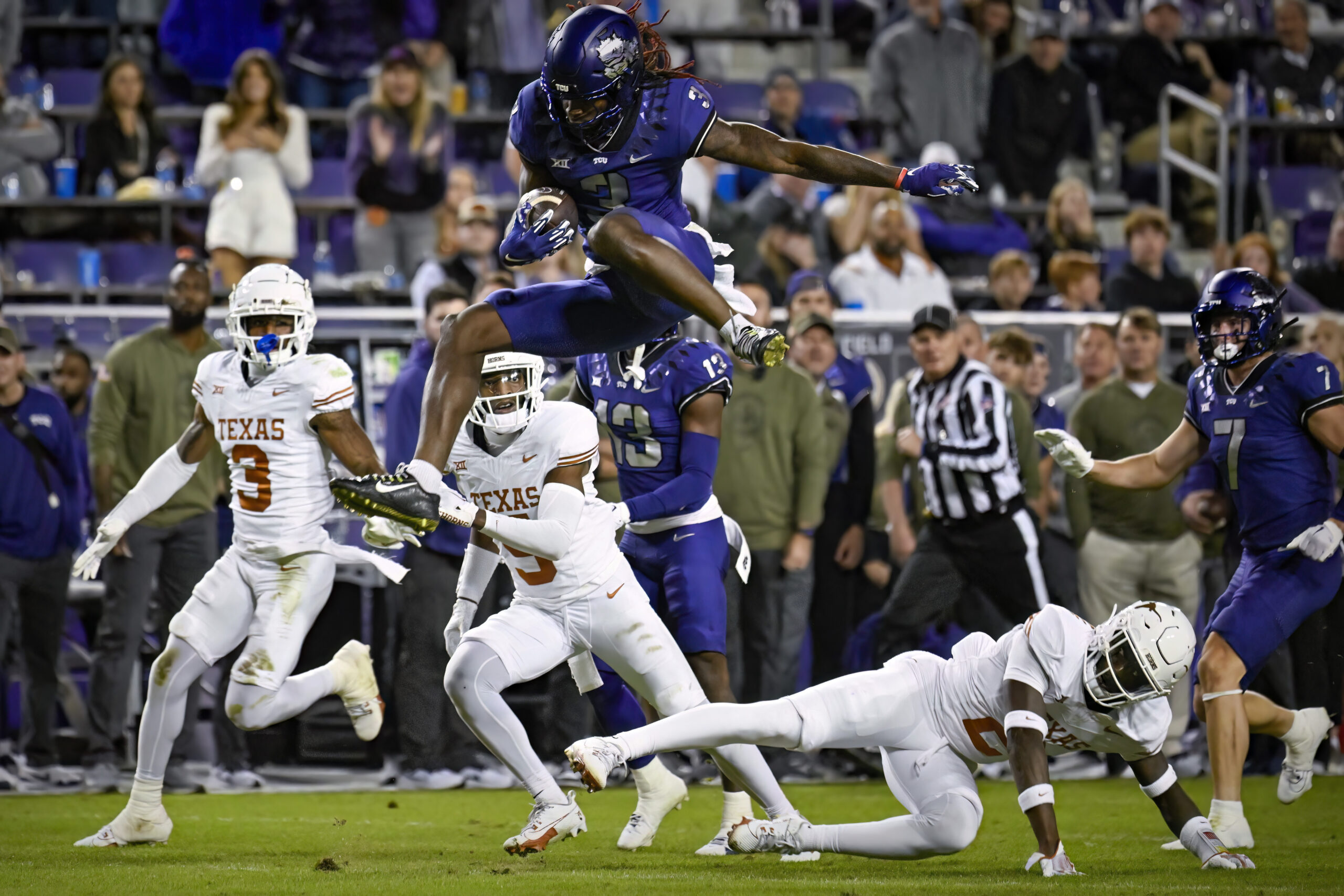 Nov 11, 2023; Fort Worth, Texas, USA; TCU Horned Frogs wide receiver Savion Williams (3) leaps over Texas Longhorns defensive back Derek Williams Jr. (2) during the second half at Amon G. Carter Stadium.