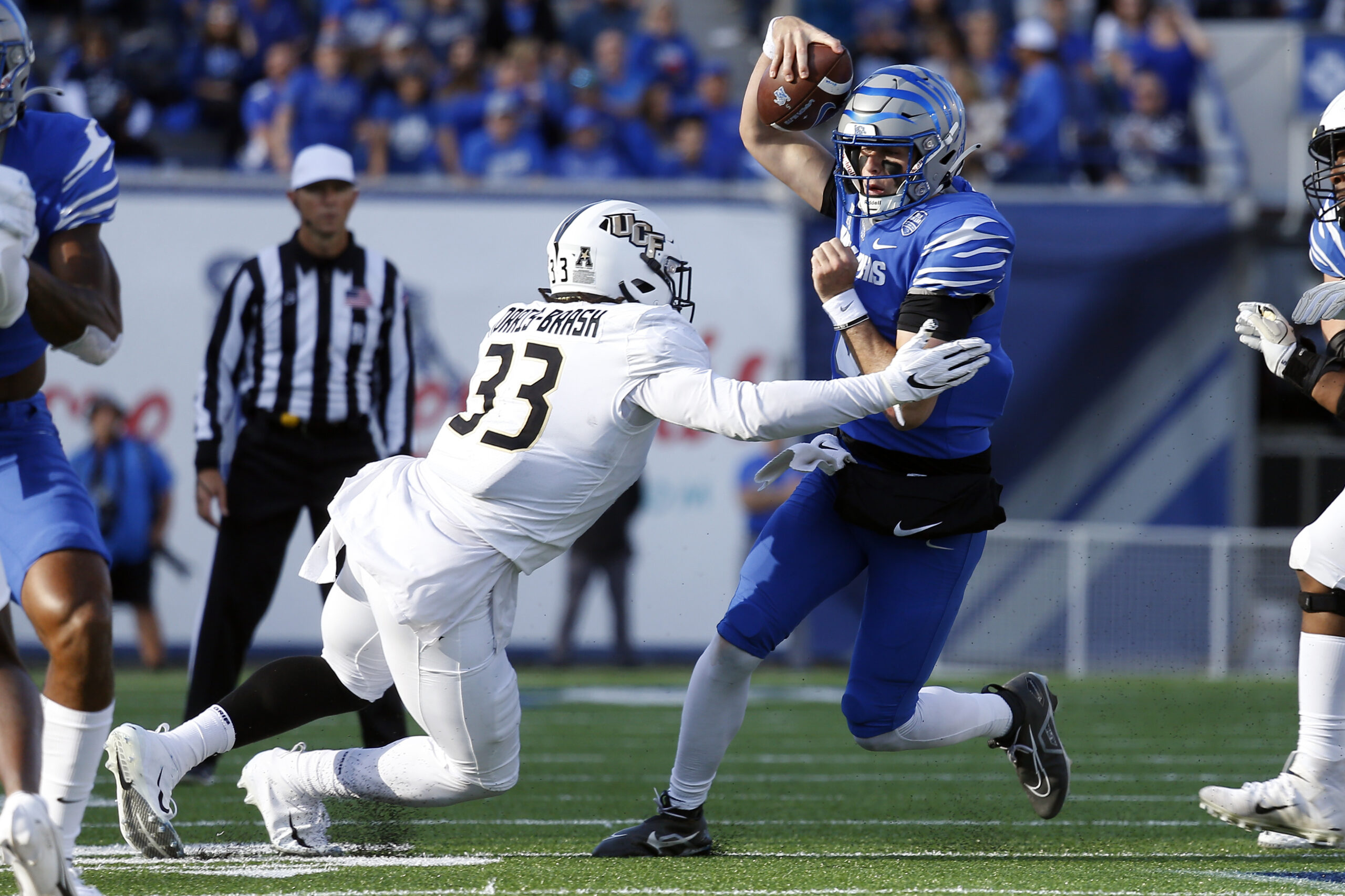 Nov 5, 2022; Memphis, Tennessee, USA; Memphis Tigers quarterback Seth Henigan (5) runs the ball as UCF Knights defensive end Tre'mon Morris-Brash (33) attempts to make the tackle during the first half at Liberty Bowl Memorial Stadium.