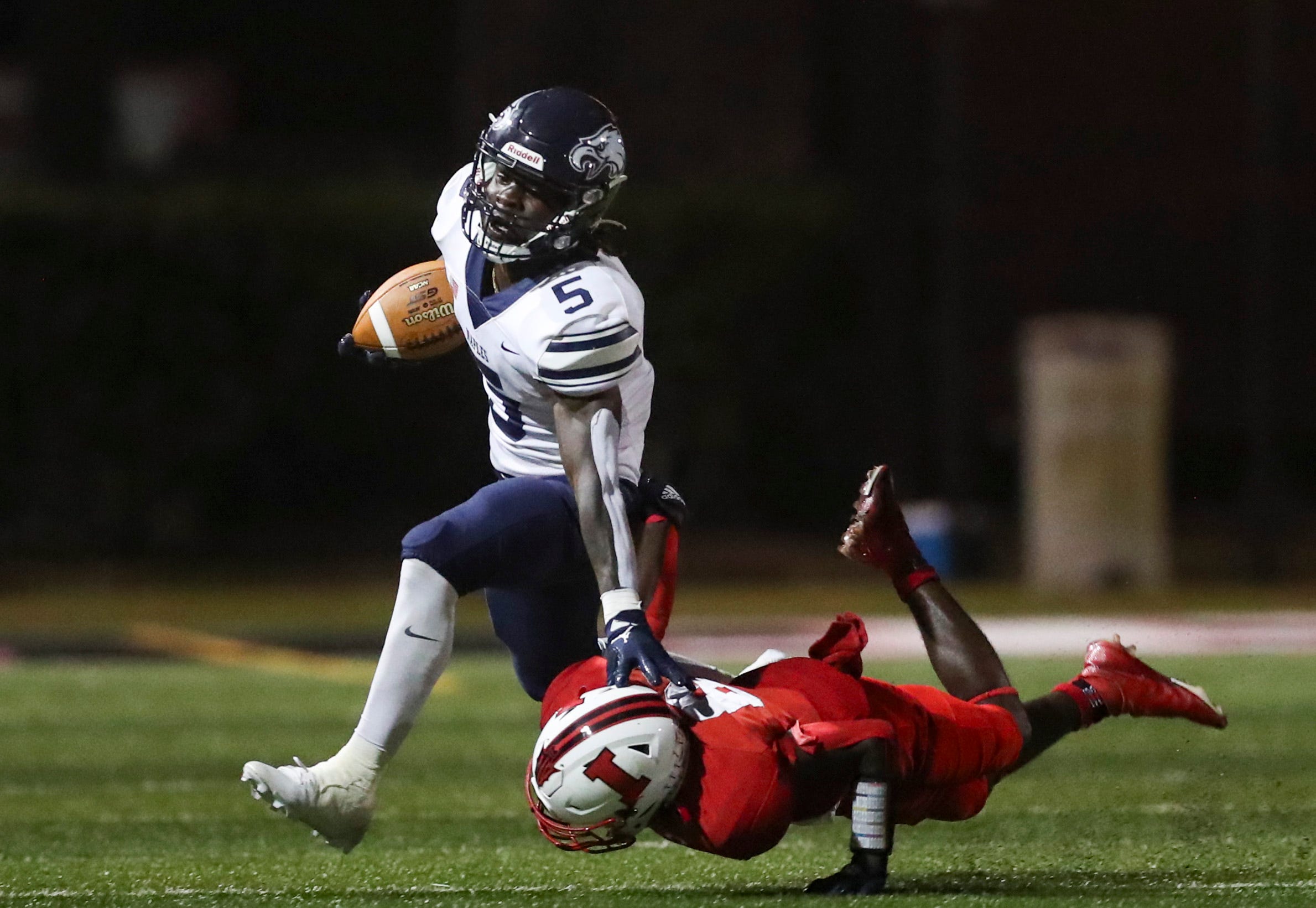 Naples Golden Eagles running back Shawn Simeon (5) stiff arms an Immokalee Indians defender while running the ball during the second quarter of a game at Gary Bates Stadium in Immokalee on Friday, Sept. 8, 2023.