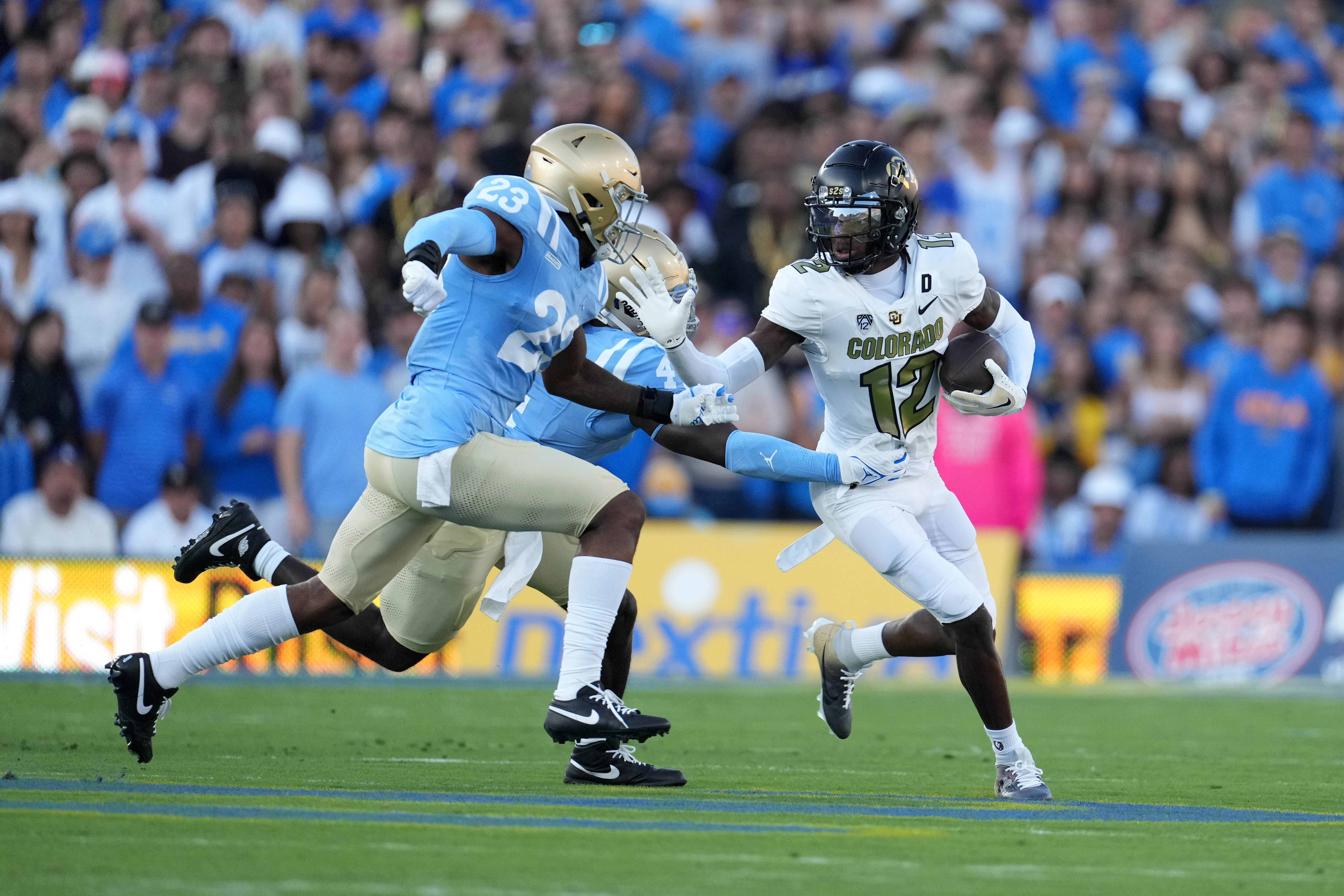 Oct 28, 2023; Pasadena, California, USA; Colorado Buffaloes quarterback Shedeur Sanders (2) carries the ball against UCLA Bruins defensive back Kenny Churchwell III (23) in the first half at Rose Bowl.