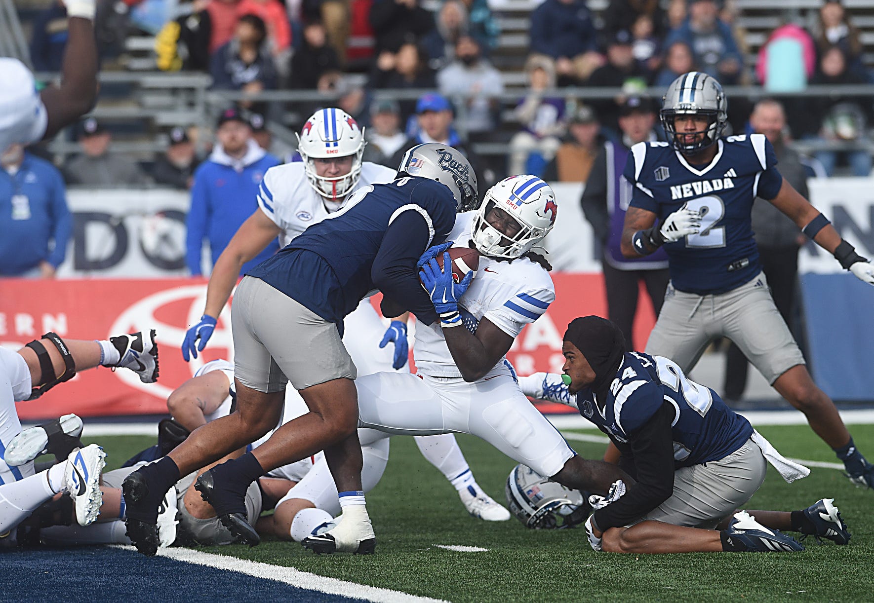 Nevada’s Henry Ikahihifo (0) and Chad Brown (24) stop SMU’s LJ Johnson from scoring at Mackay Stadium in Reno on Aug. 24, 2024.