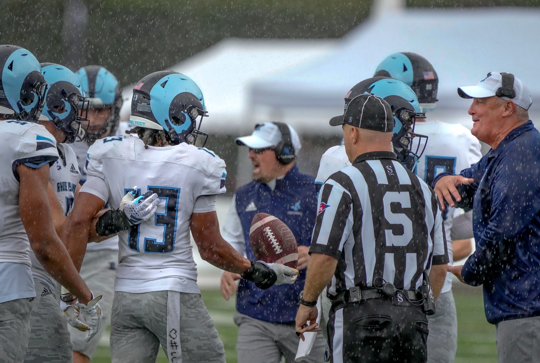 Syeed Gibbs tosses URI coach Jim Fleming the game ball after his game ending interception.