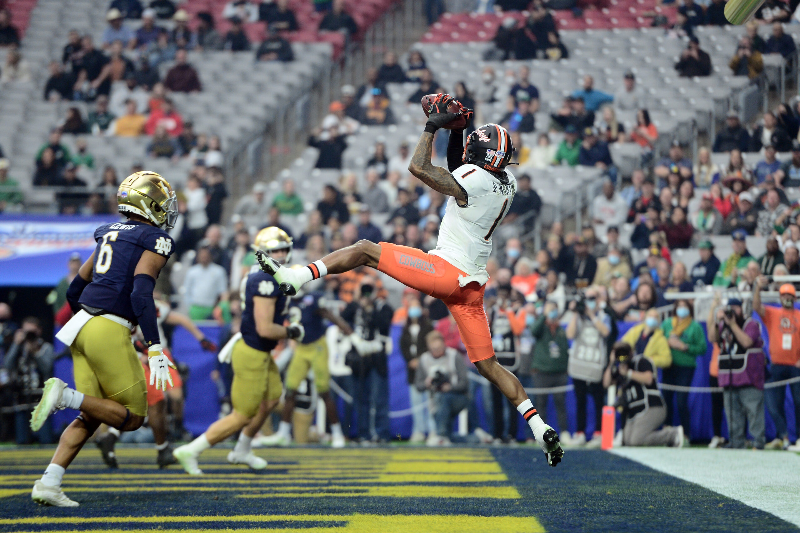 Jan 1, 2022; Glendale, Arizona, USA; Oklahoma State Cowboys wide receiver Tay Martin (1) catches a touchdown pass against the Notre Dame Fighting Irish during the first half of the 2022 Fiesta Bowl at State Farm Stadium.