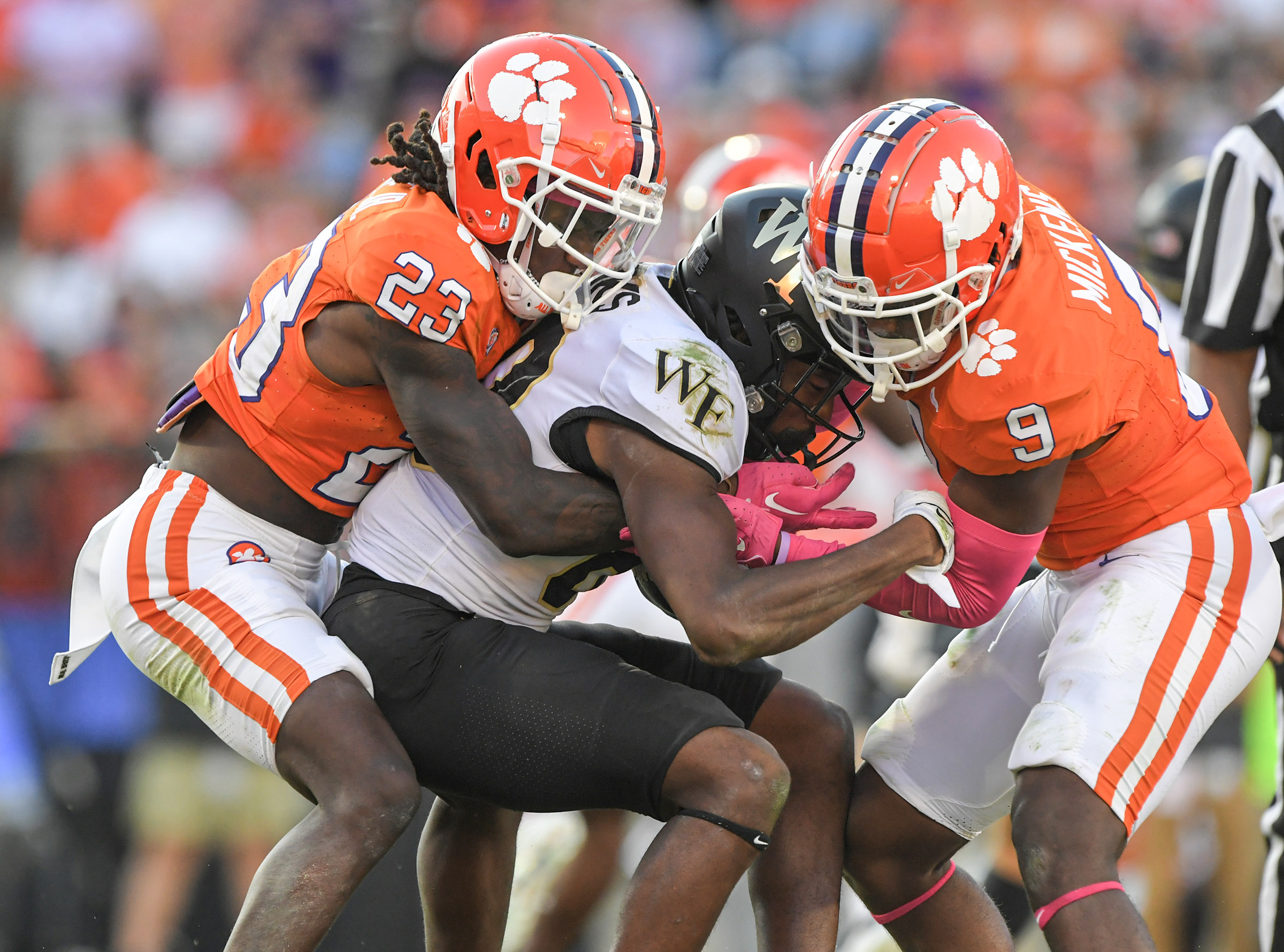 Oct 7, 2023; Clemson, South Carolina, USA; Clemson Tigers cornerback Toriano Pride Jr. (23) and safety R.J. Mickens (9) tackle Wake Forest Demon Deacons defensive back Justin Simpkins (80) during the fourth quarter at Memorial Stadium.